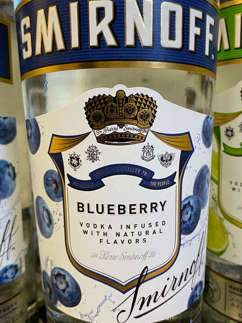 A bottle of smirnoff blueberry vodka infused with natural flavors