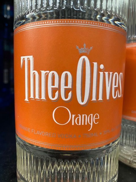 A close up of a bottle of three olives orange