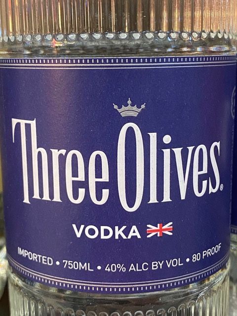 A close up of a bottle of three olives vodka