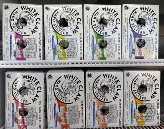 White Claw hard seltzer packs in a refrigerator.