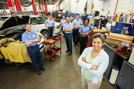 Team of auto repair mechanics standing together in a shop