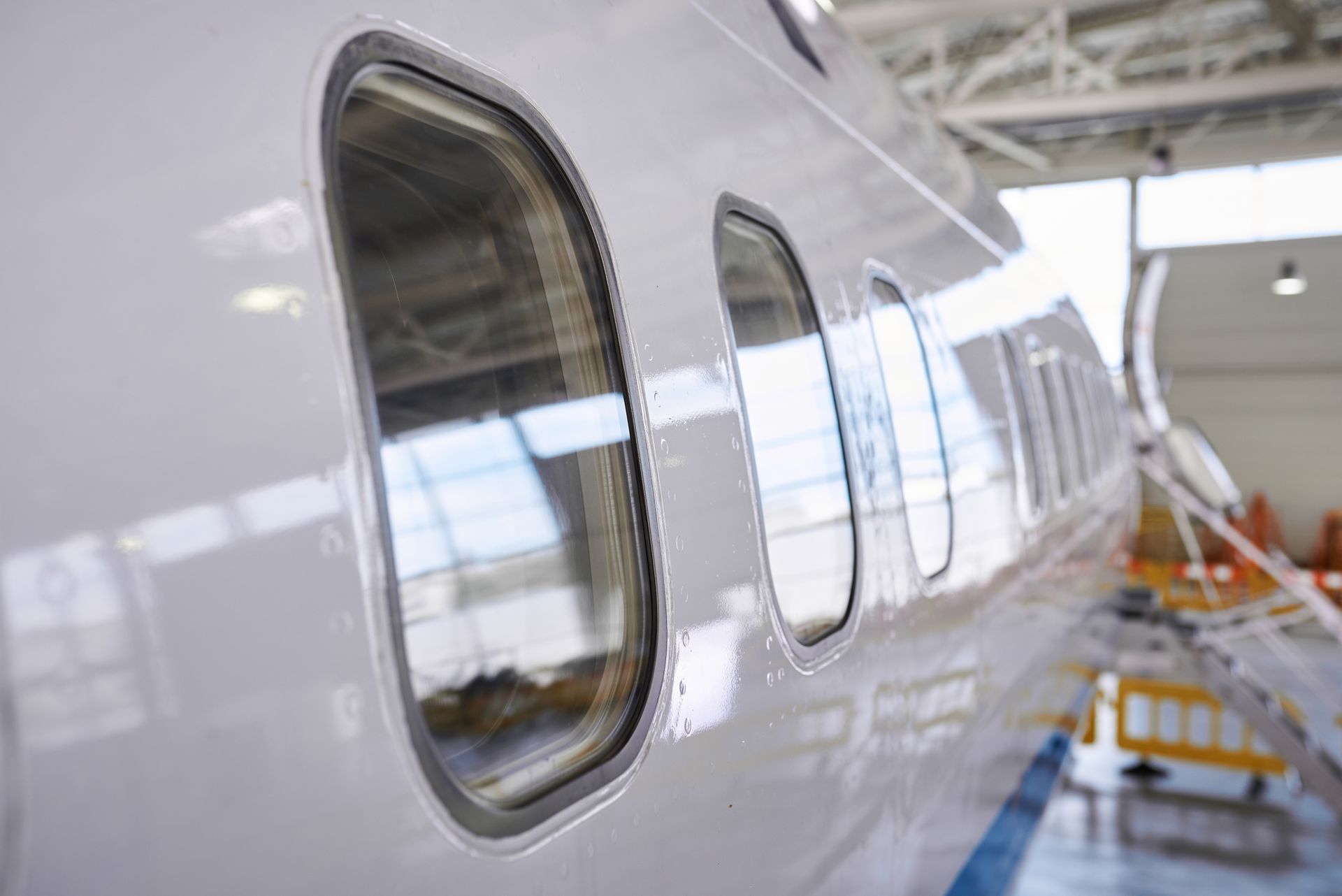 Two men are working on an airplane engine in a hangar.