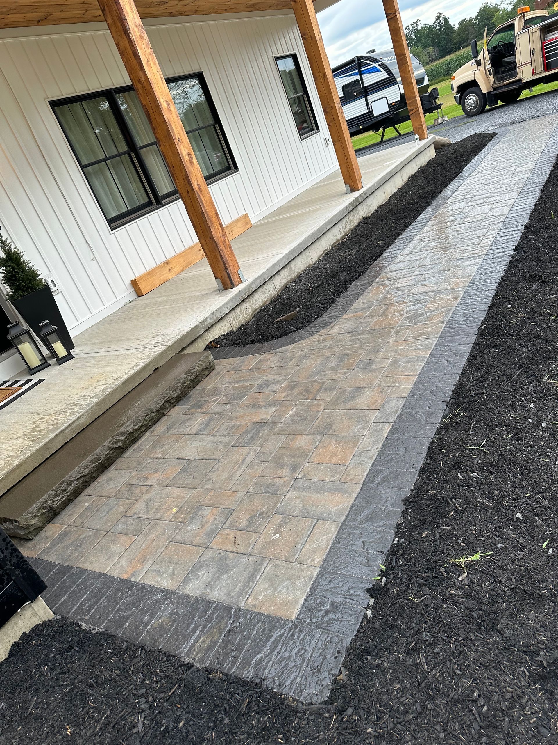 A brick walkway is being built in front of a house.