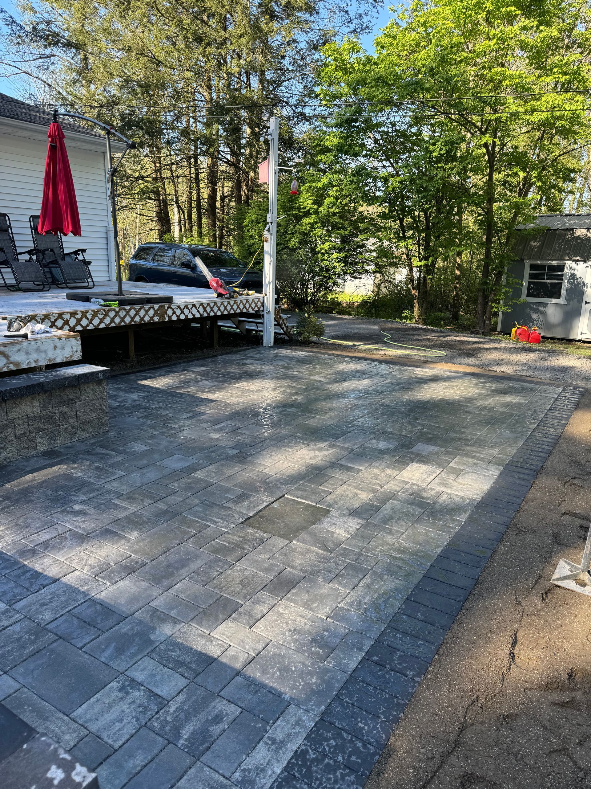 A patio is being built in the backyard of a house.