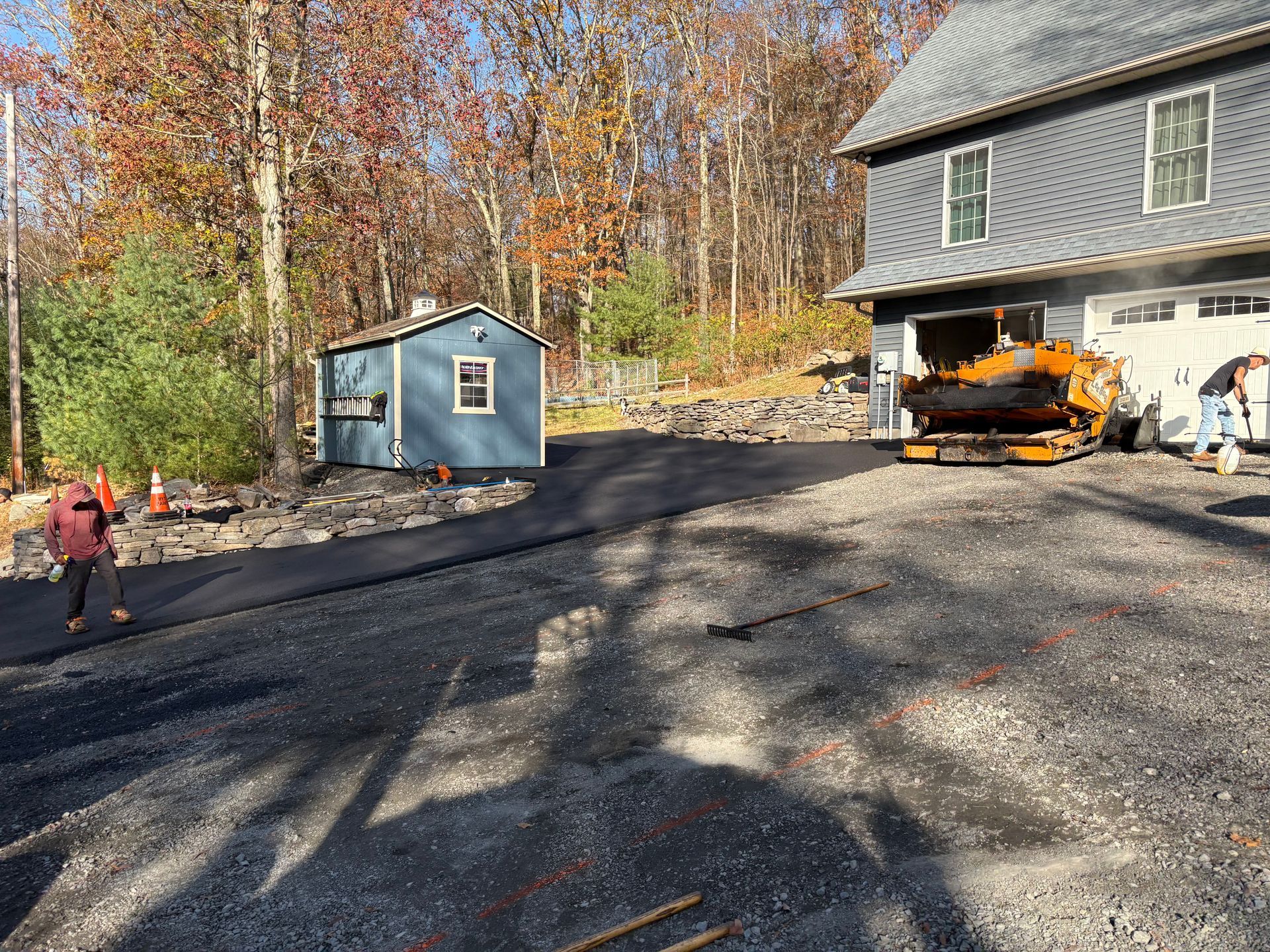 A driveway is being paved in front of a house.