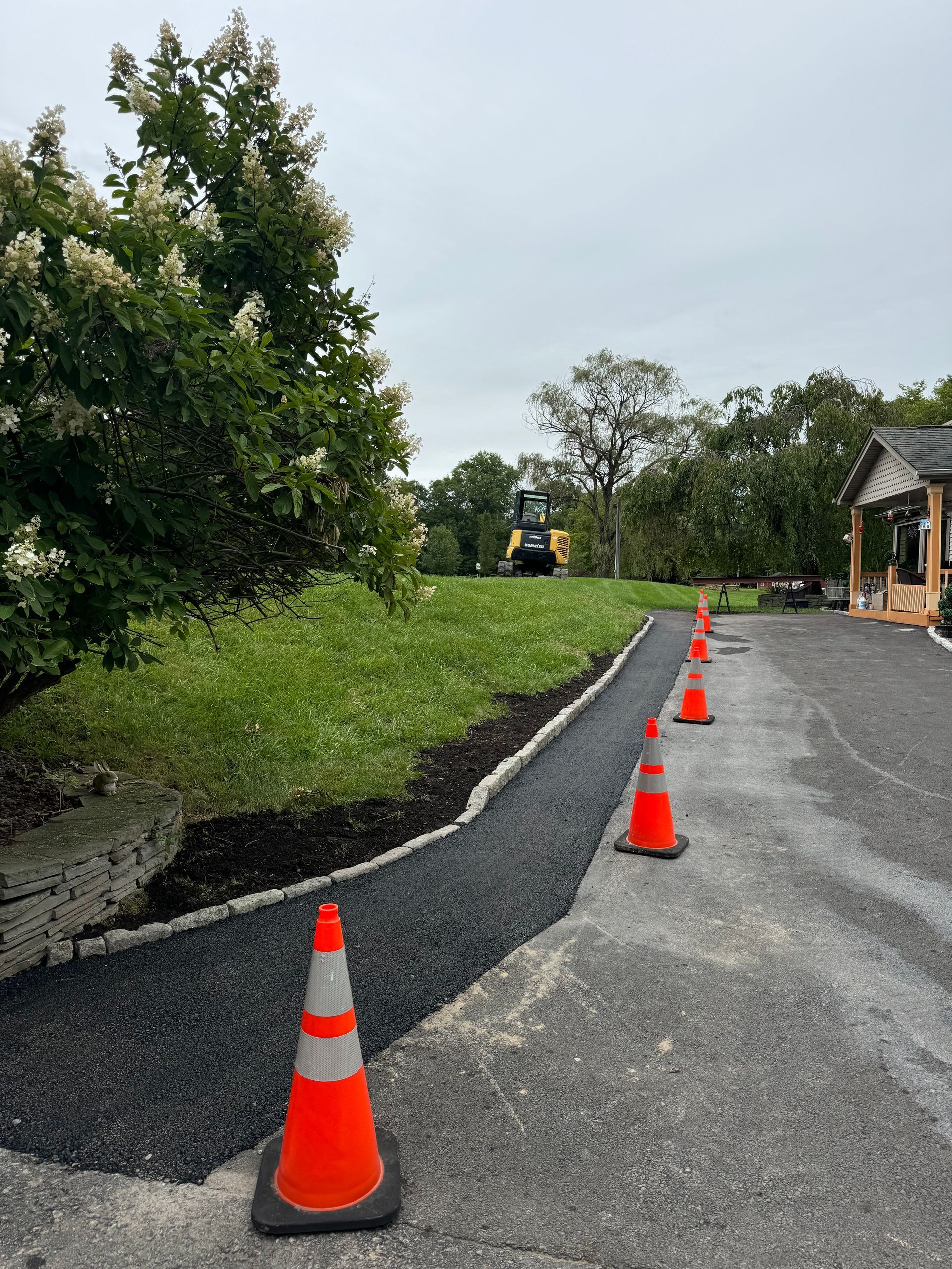 A row of orange and white traffic cones on the side of a road.