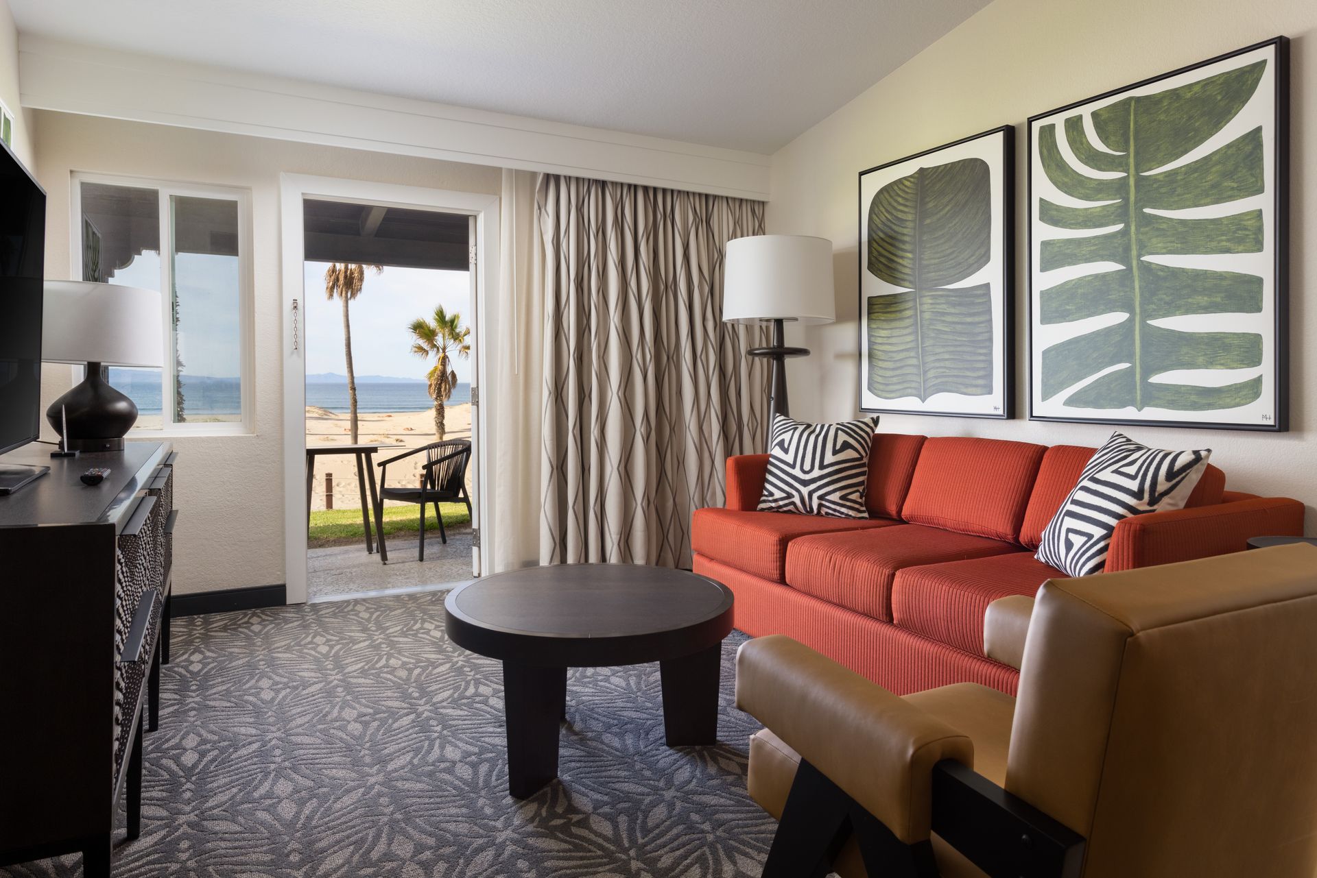 A living room with a couch , chair , table and television.