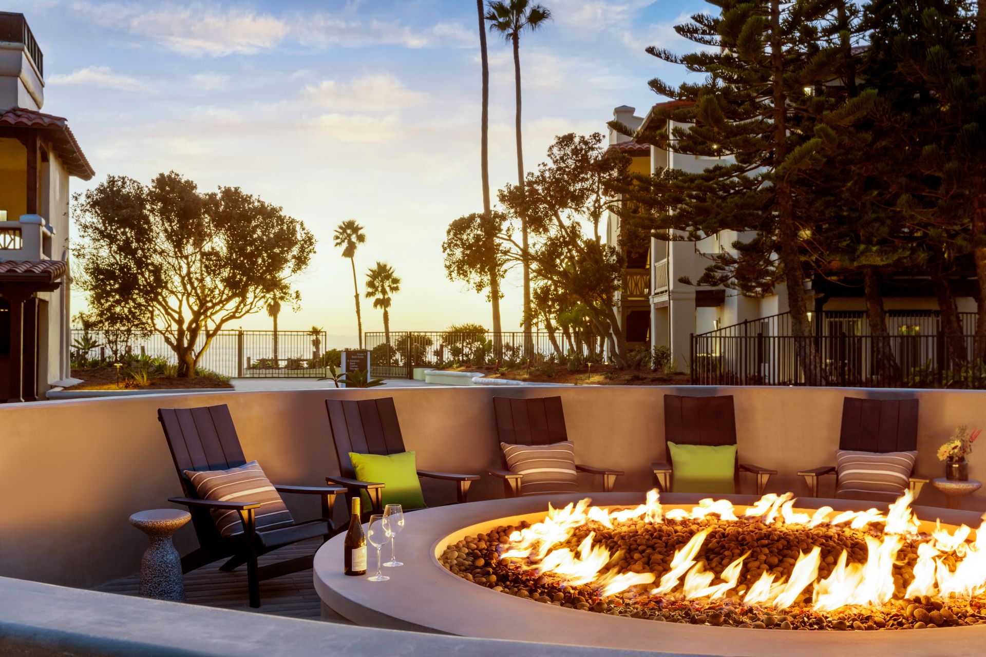 A fire pit surrounded by chairs and a bottle of wine