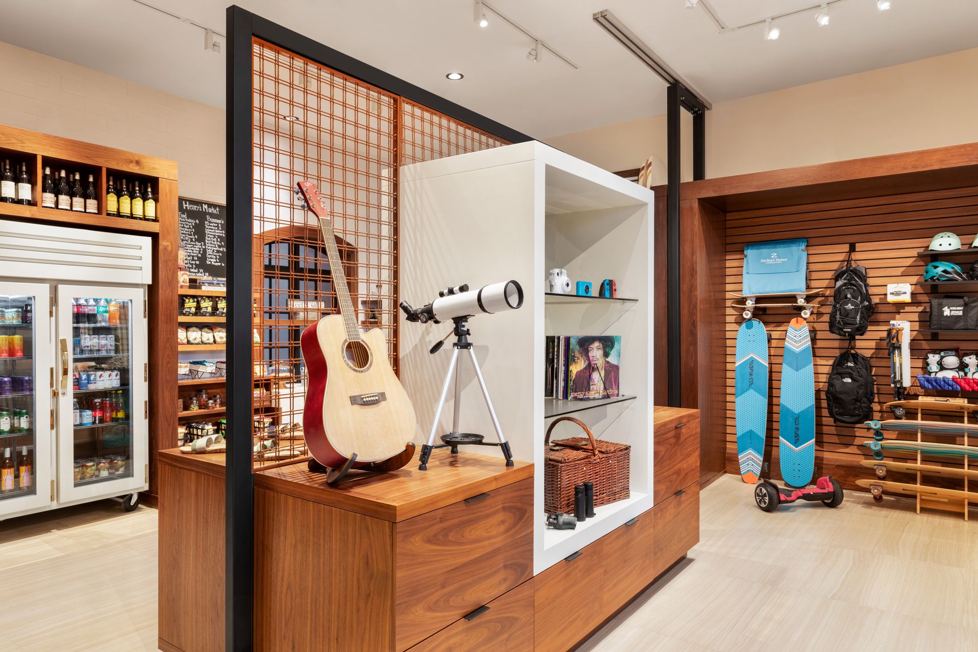 A guitar , telescope , and skateboard are on display in a store.