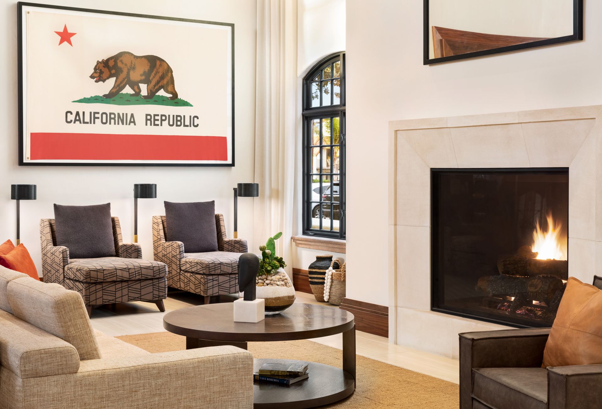 A living room with a fireplace and a california republic flag on the wall