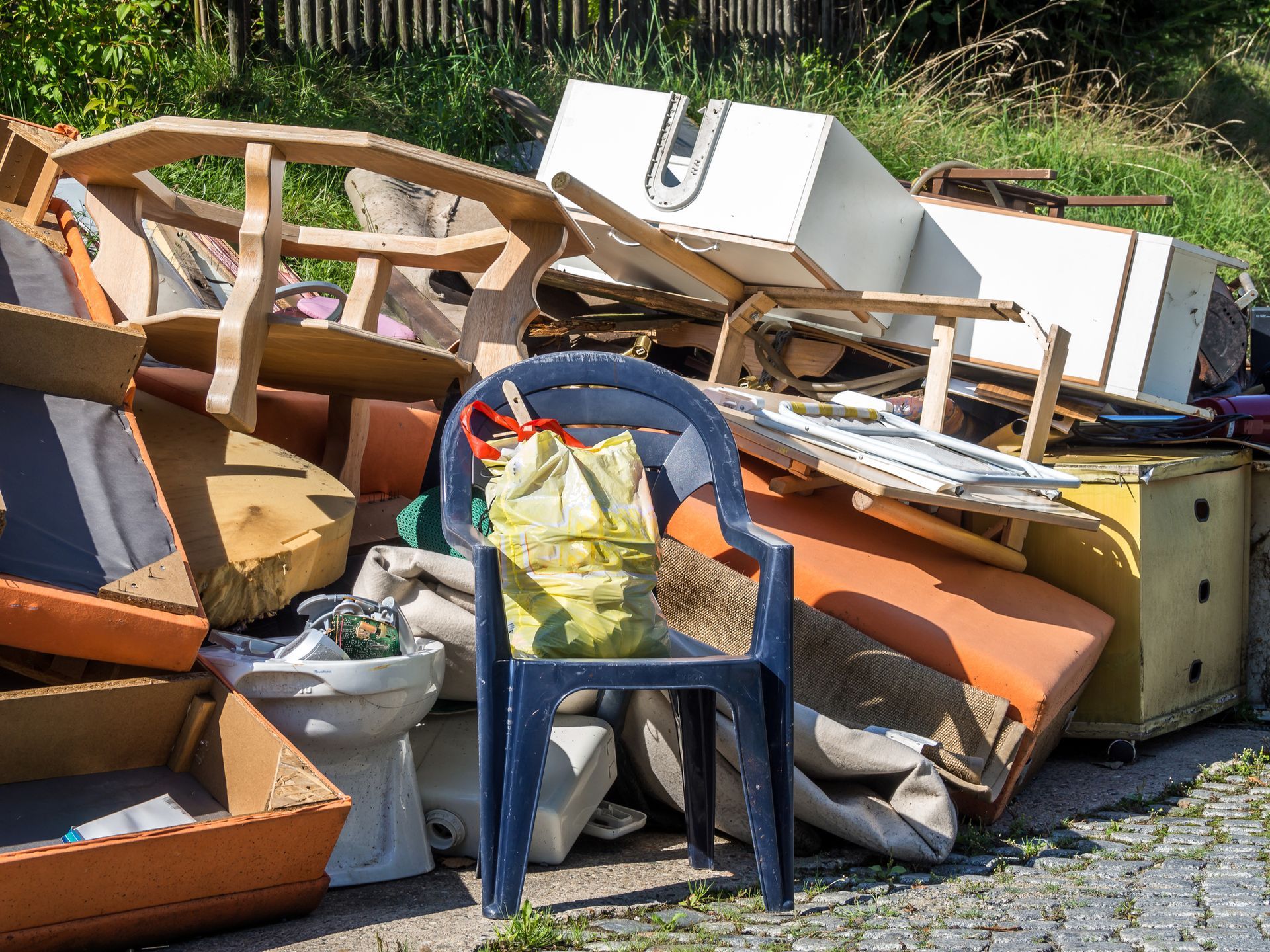 A chair is sitting in front of a pile of trash.