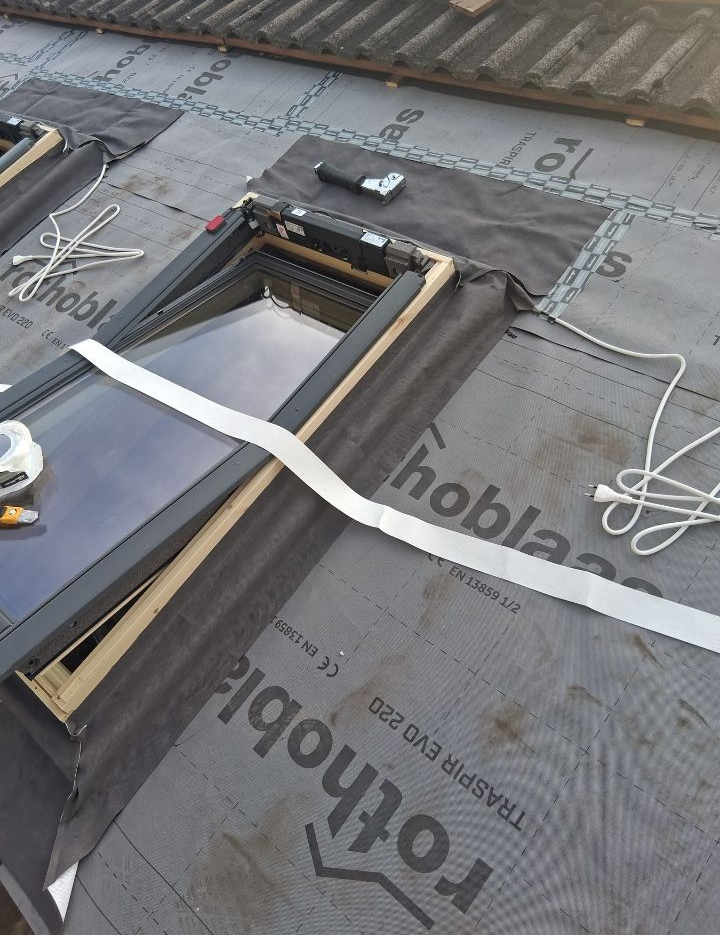 Sottostrato di copertura intorno all'apertura del lucernario con telaio in legno e membrana di copertura grigia.
