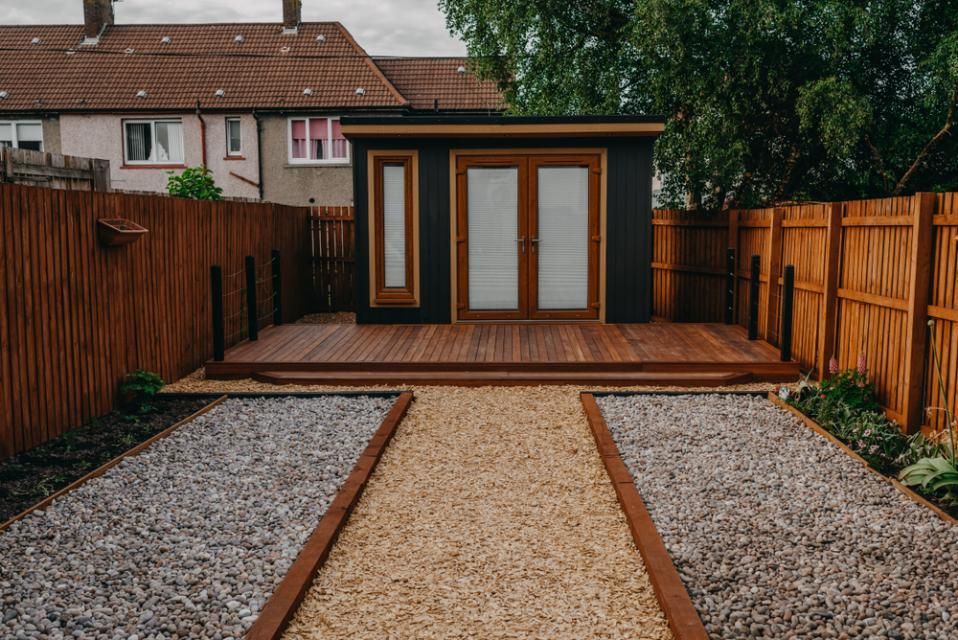 A Small House With a Wooden Deck and a Wooden Fence in a Backyard— Cutting Edge Painting Contractors QLD in The Dawn, QLD