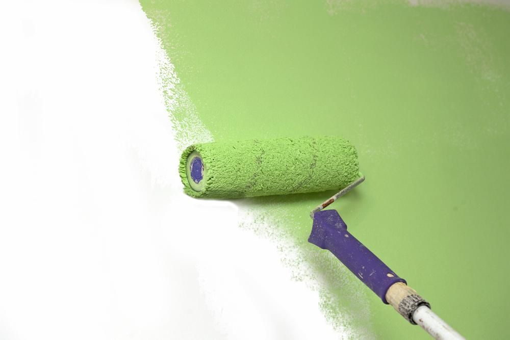 A Paint Roller is Painting a Wall Green — Cutting Edge Painting Contractors QLD in Chatsworth, QLD