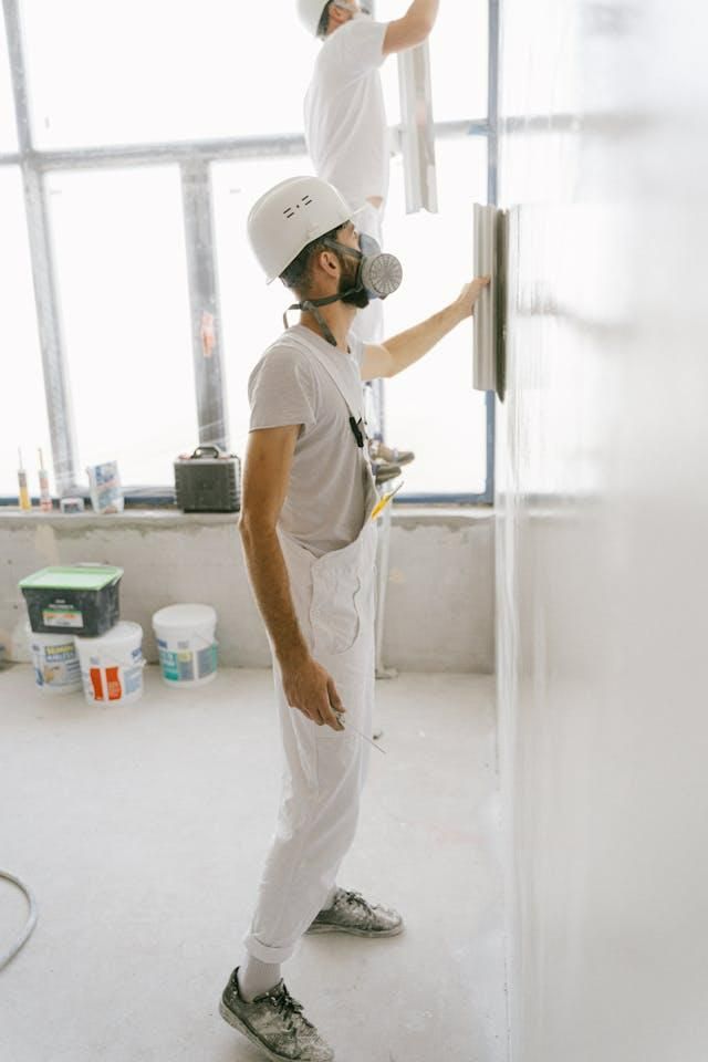 Two Men Are Plastering a Wall in a Room — Cutting Edge Painting Contractors QLD in Kilkivan, QLD