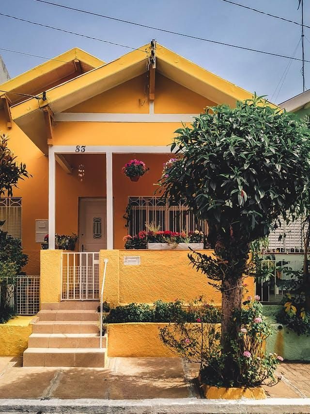 A Yellow House With a Tree in Front of It — Cutting Edge Painting Contractors QLD in Kilkivan, QLD