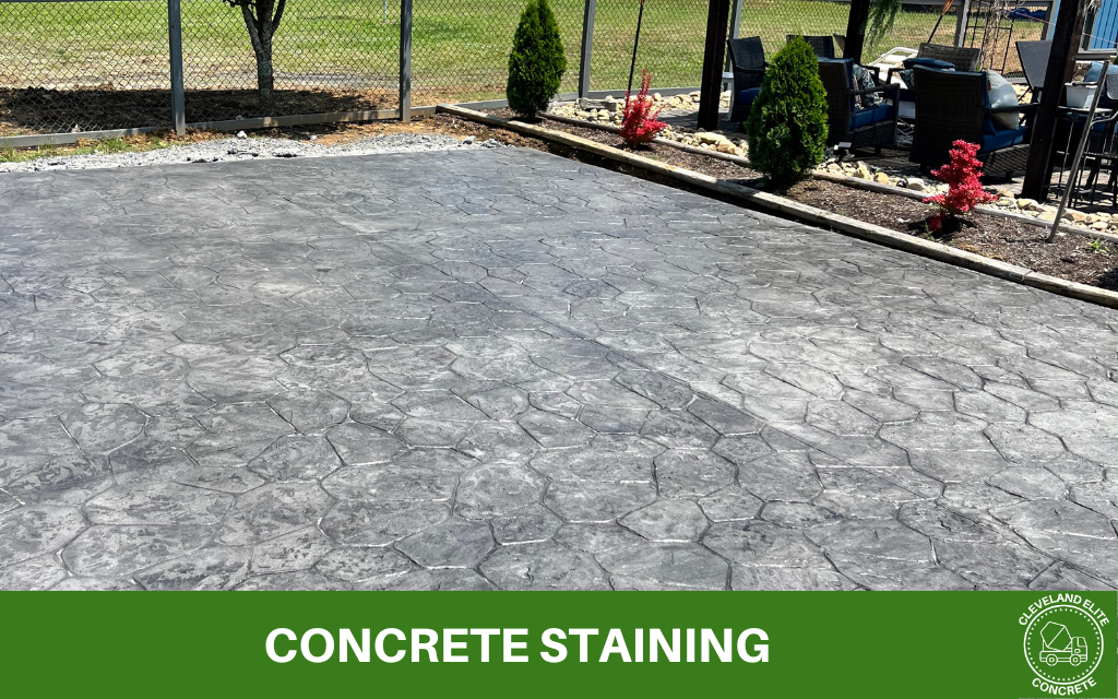 image of a freshly stained stamped concrete patio with text underneath that says concrete staining and the cleveland elite concrete logo