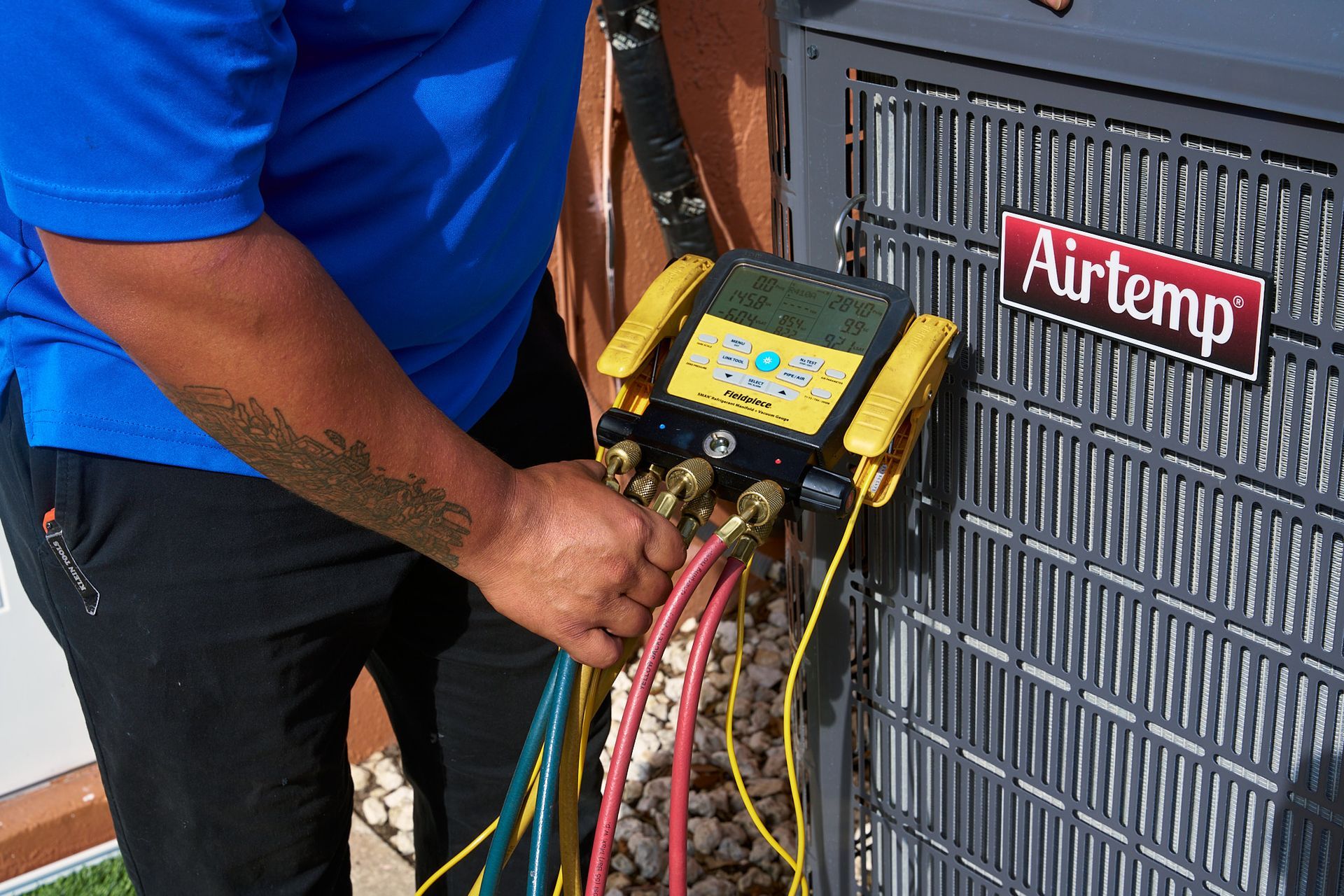 Technician using a multimeter to inspect an outdoor air conditioning unit