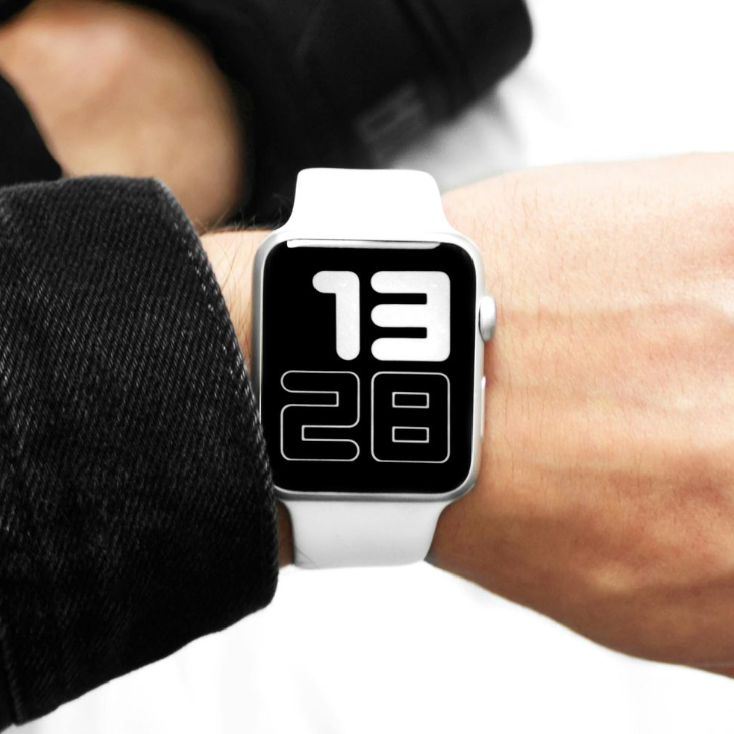 White smartwatch on wrist displaying 13:28 with a black screen and white band