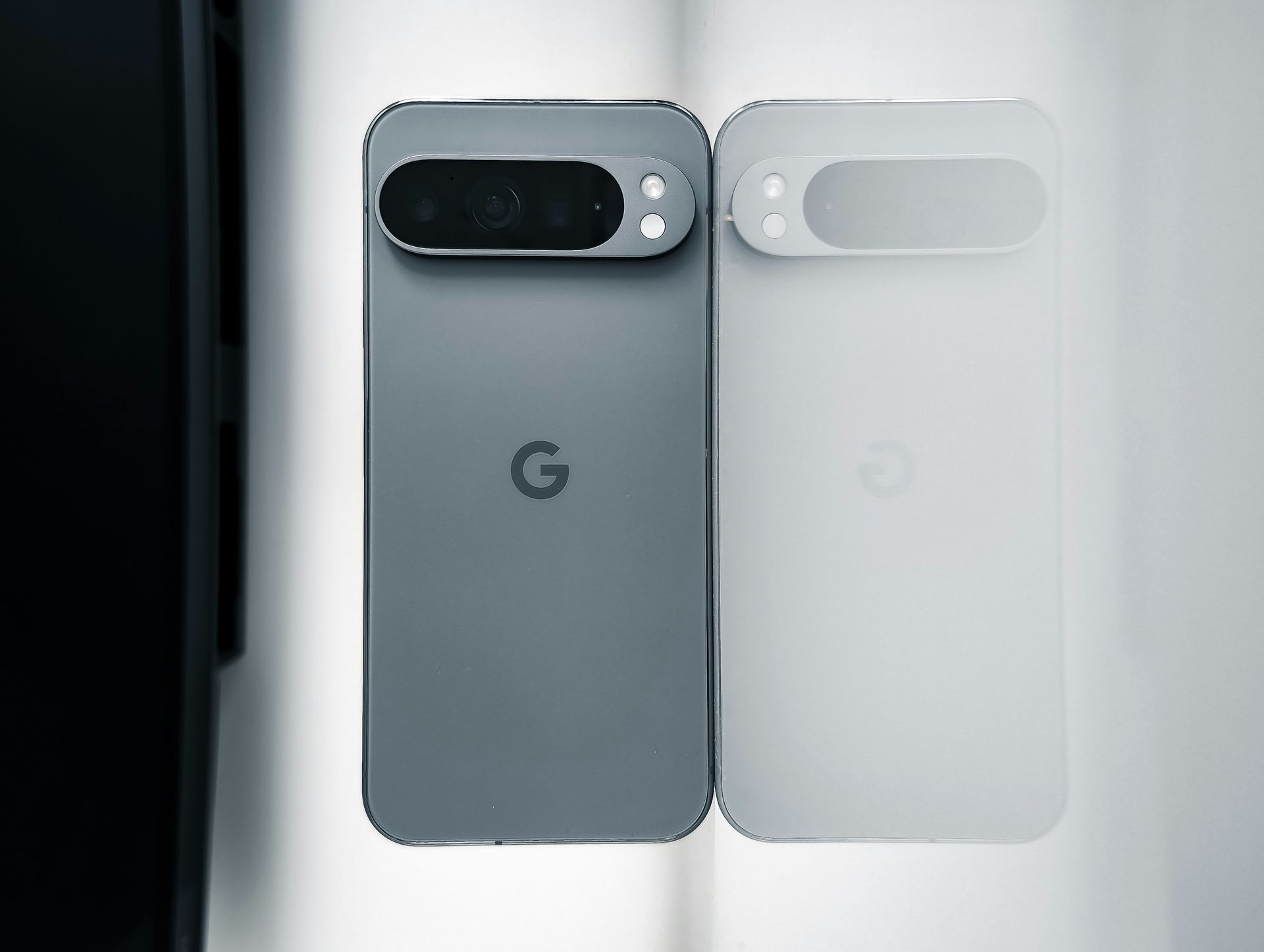 Two Google Pixel phones shown side by side, one gray and one white, back view