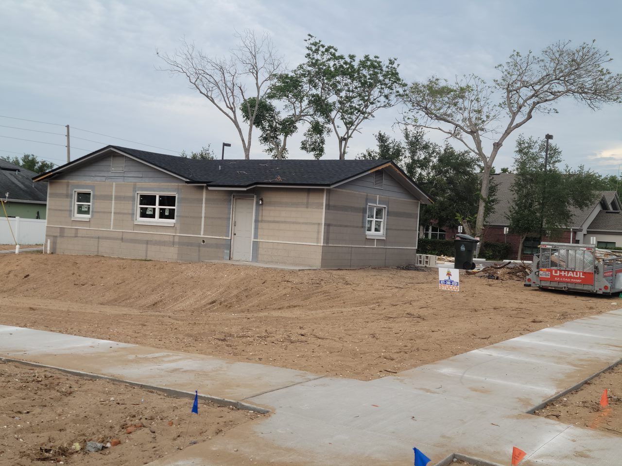 A small house is being built in a dirt lot
