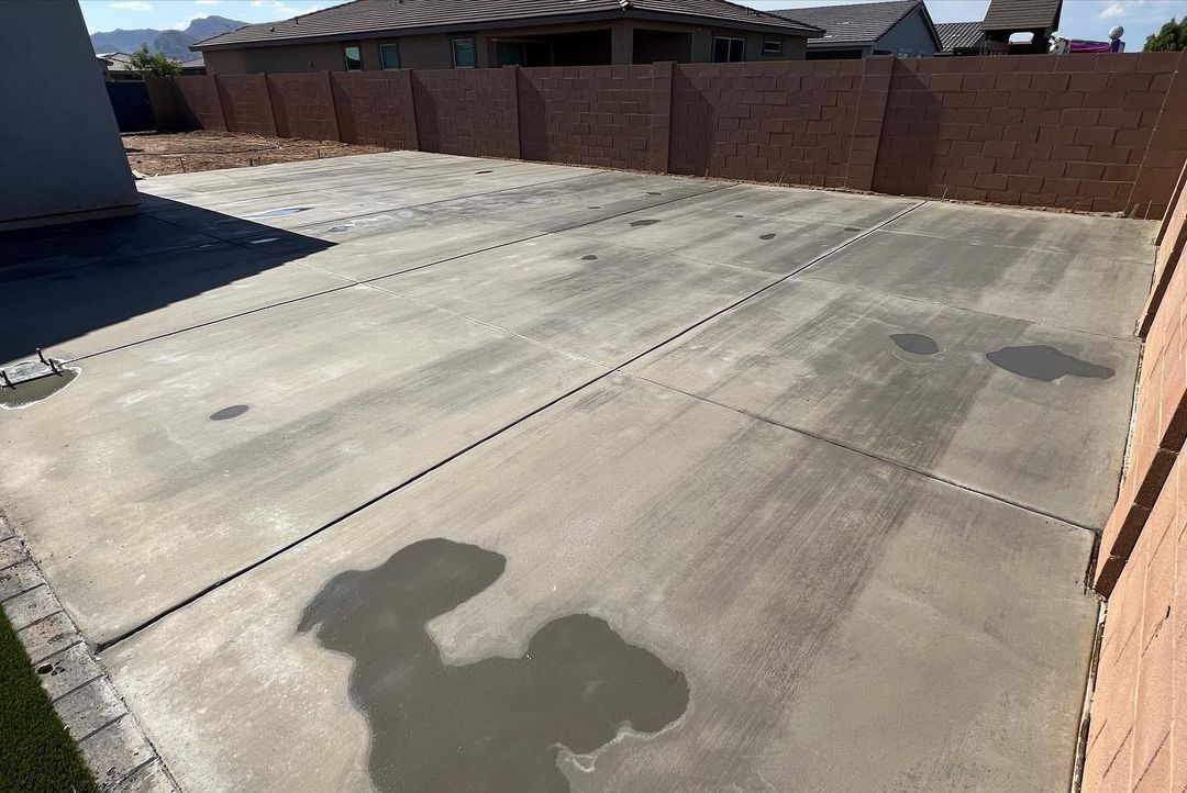 A concrete driveway with a shadow of a person on it.