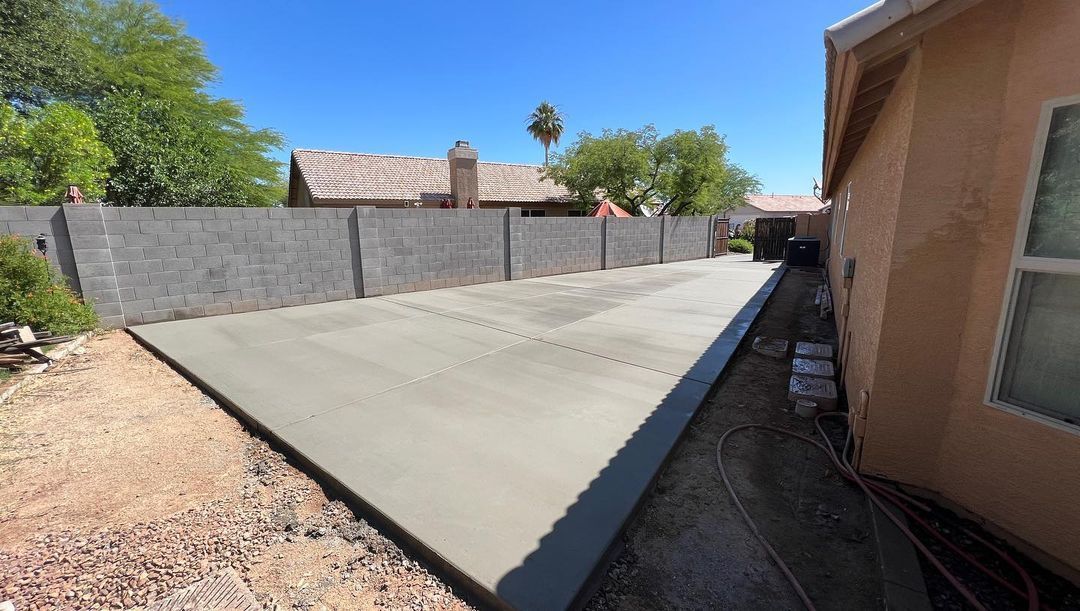 A concrete driveway is being built in front of a house.