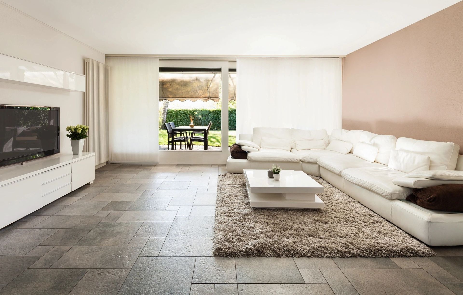 A living room with a large sectional couch and a flat screen tv