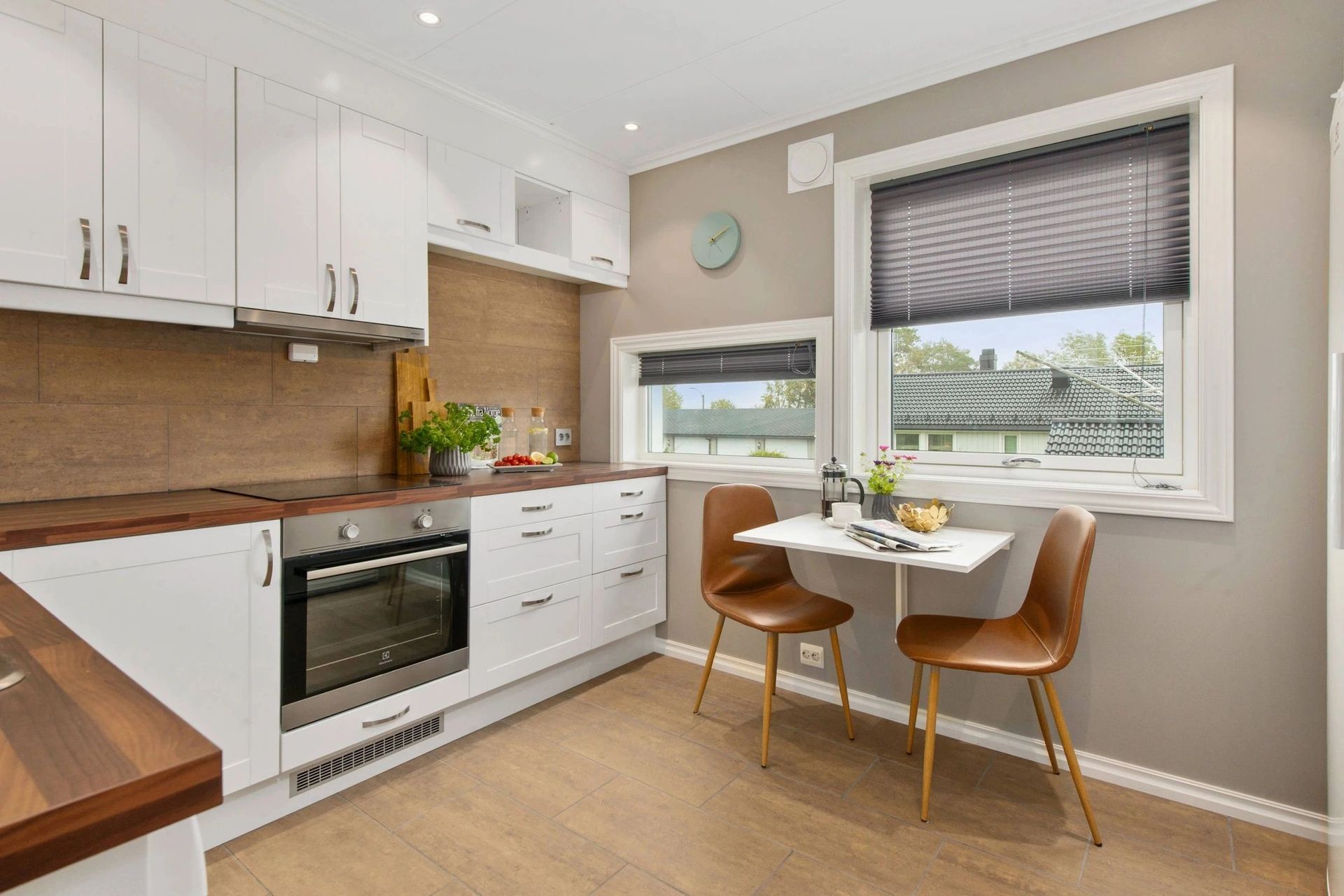 A kitchen with a table and chairs in front of a window.