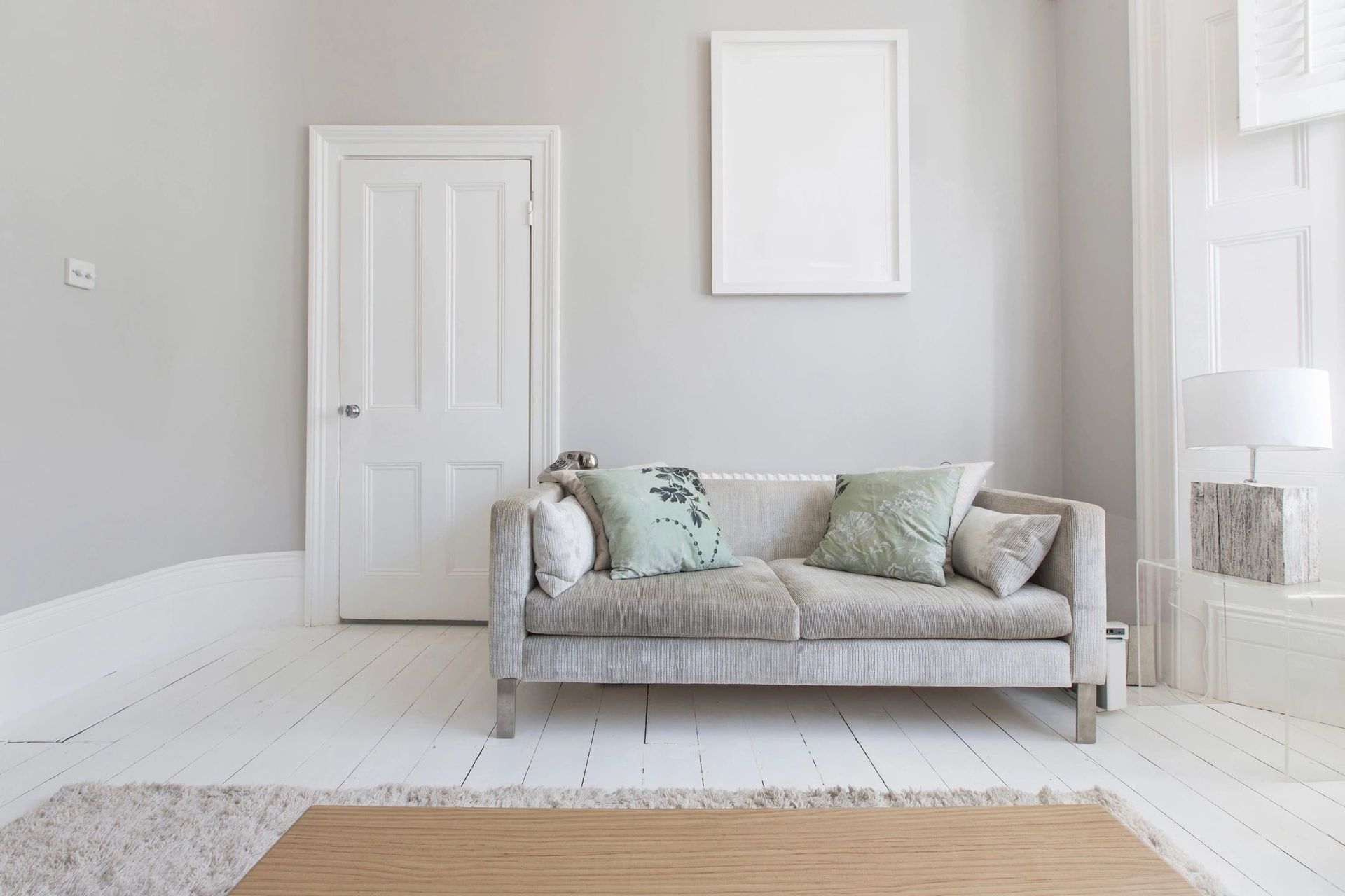 A living room with a couch and a picture on the wall.