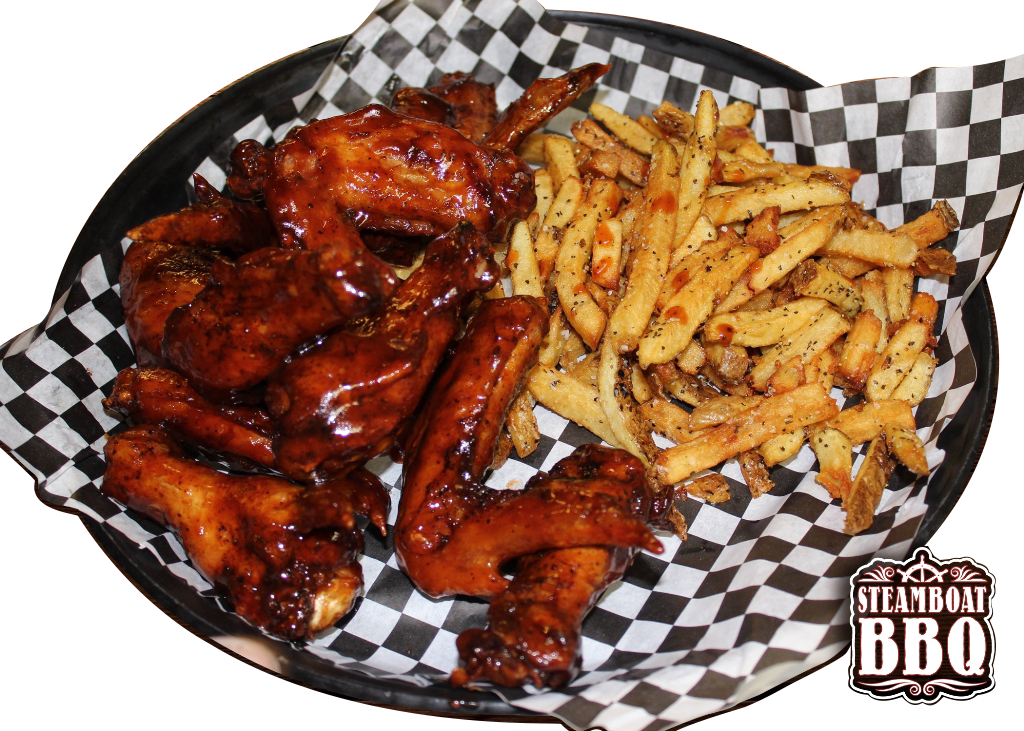 A plate of chicken wings and french fries on checkered paper