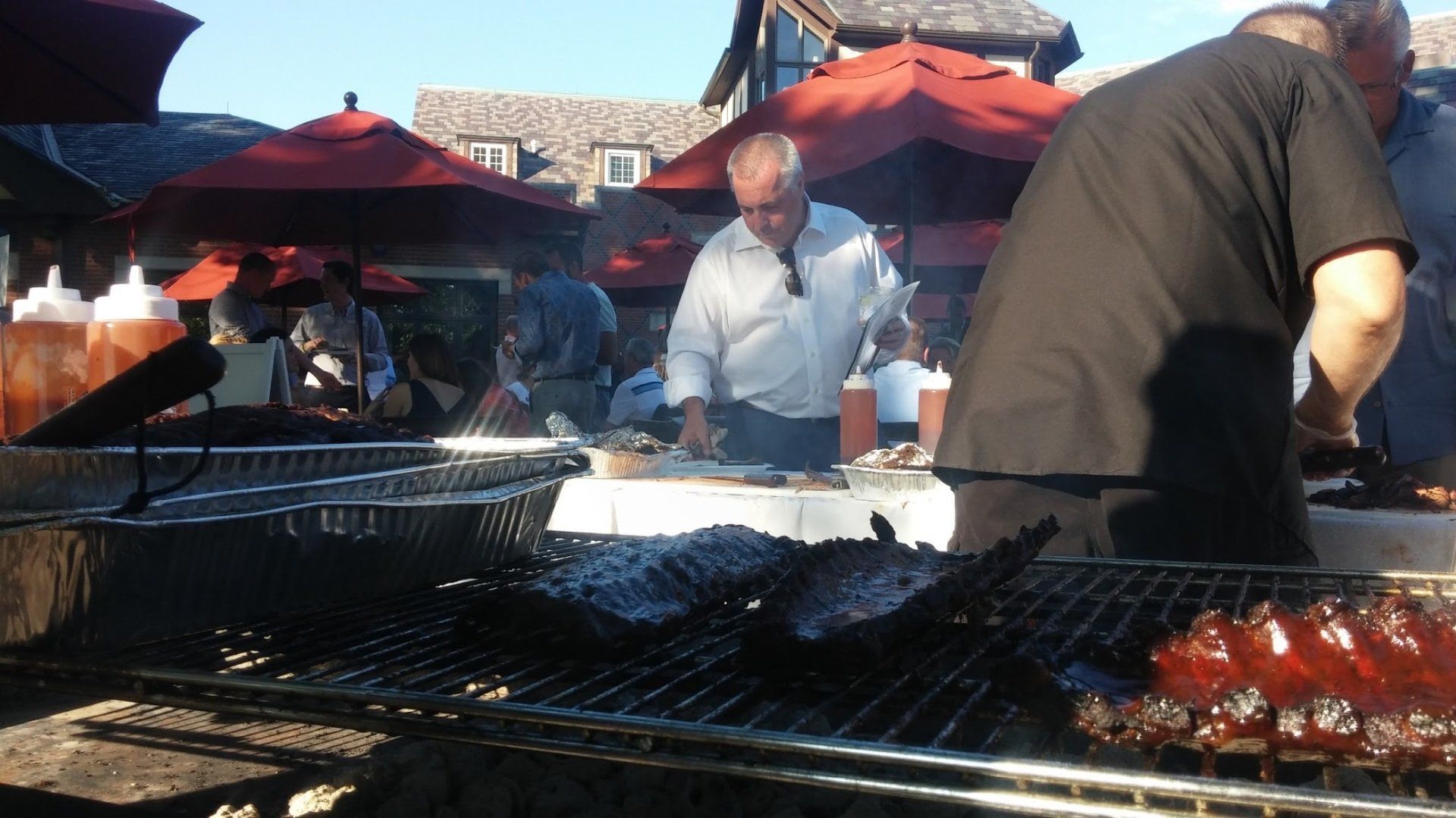 A group of people are cooking food on a grill outside