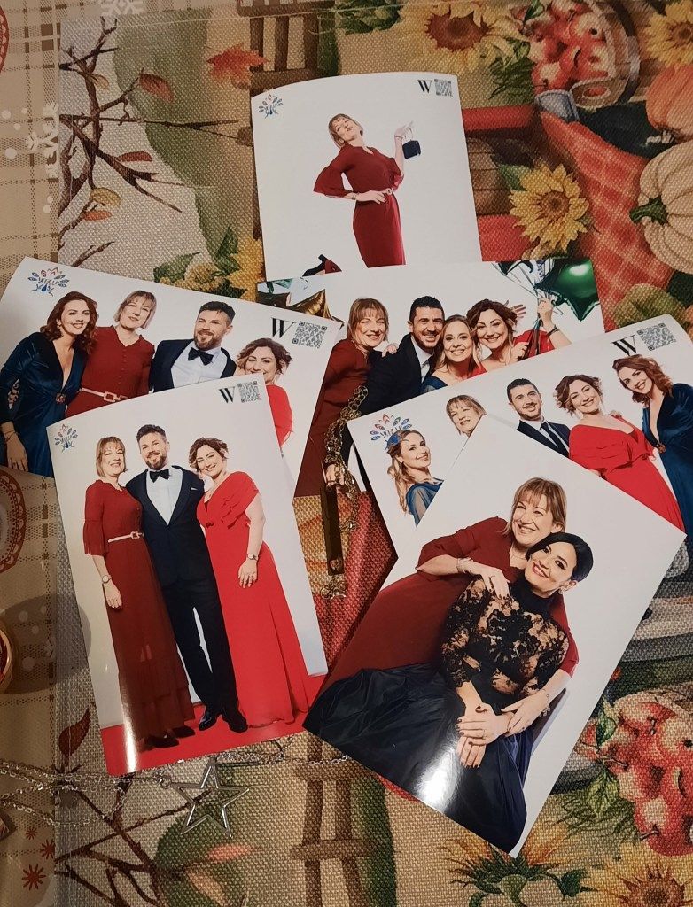 Biglietti con foto di persone in abiti formali su un tavolo decorato.