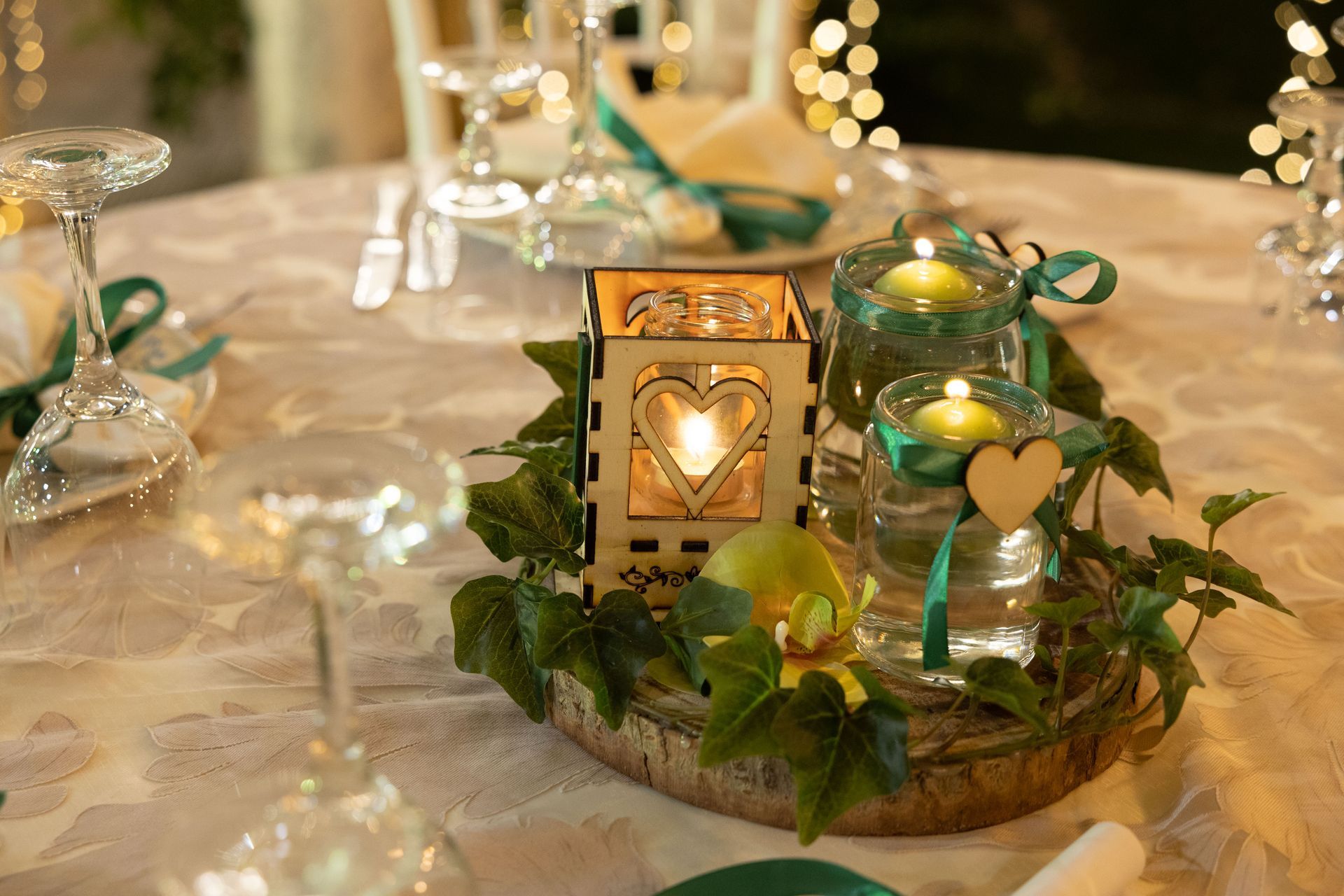 Apparecchiatura della tavola con dettagli color verde acqua, candele e decorazioni a forma di cuore per un matrimonio o un evento.