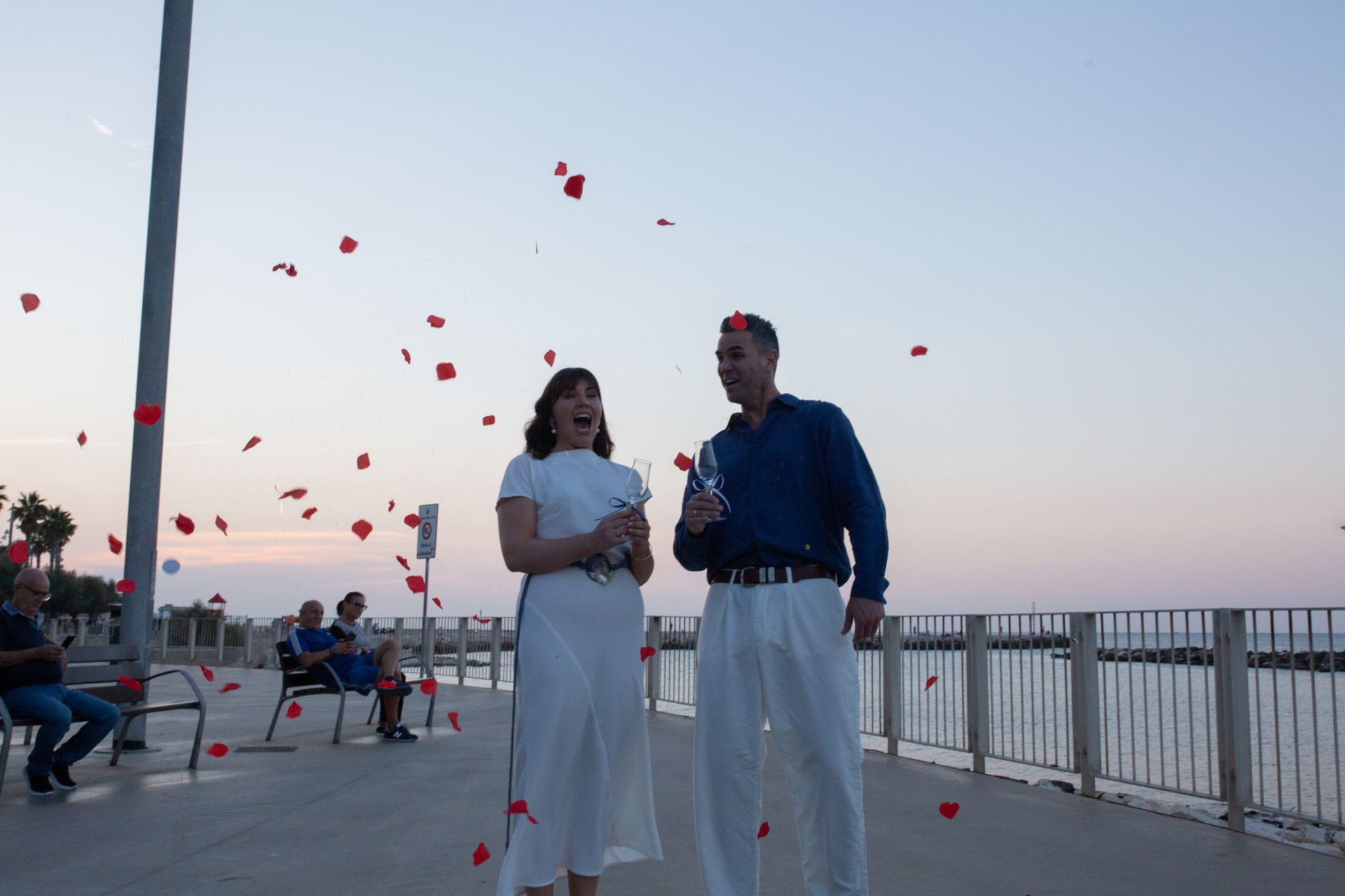 Una coppia con champagne che festeggia con petali di rose