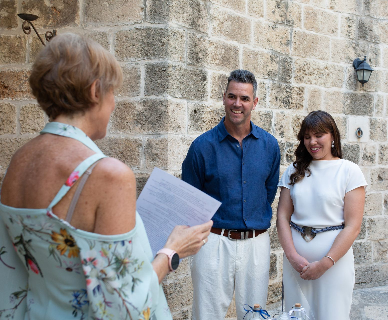 Coppia durante un rito simbolico Donna con abito bianco e uomo con camicia azzurra celebrante DP Wedding Planner