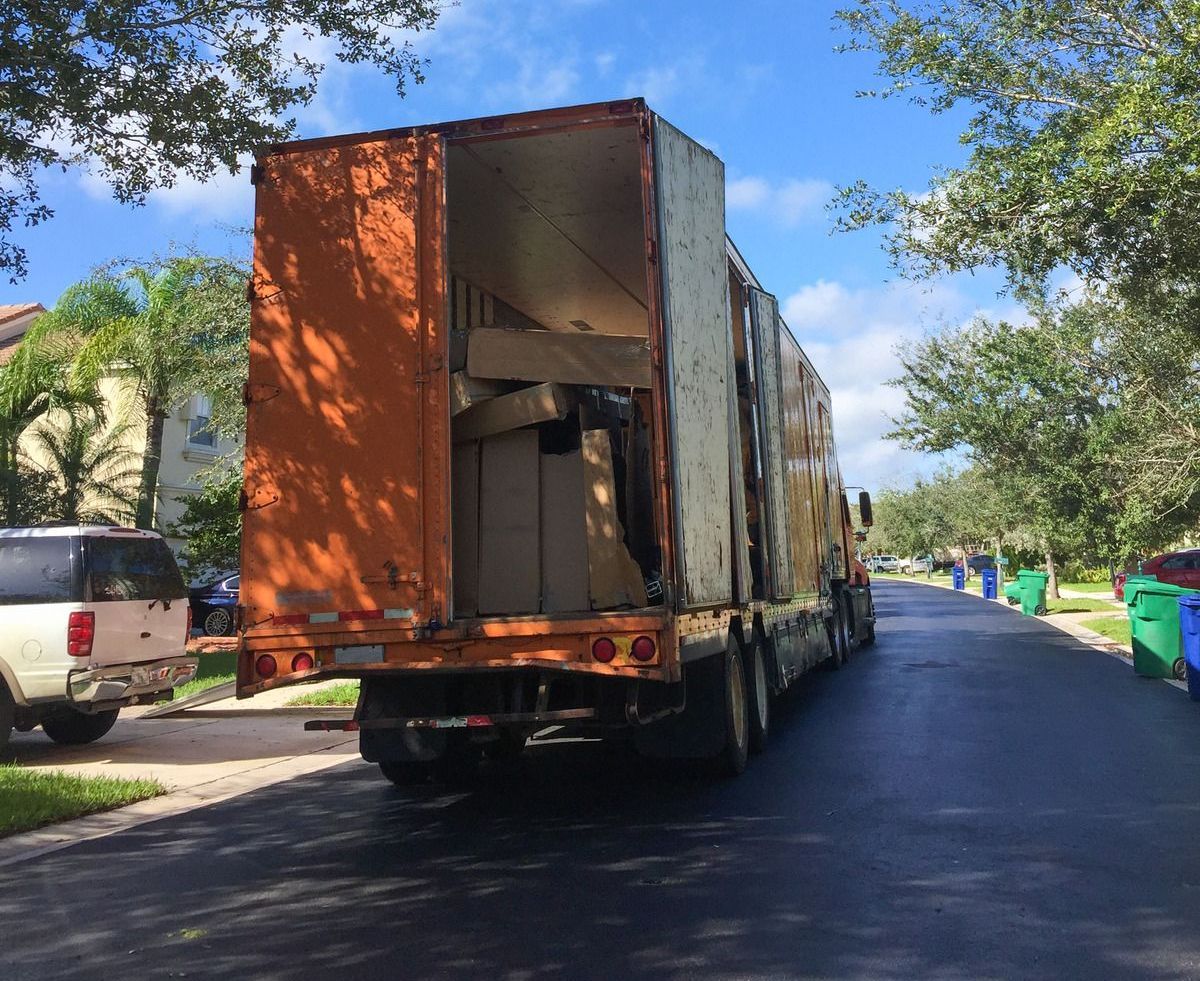 A moving truck is parked on the side of the road.