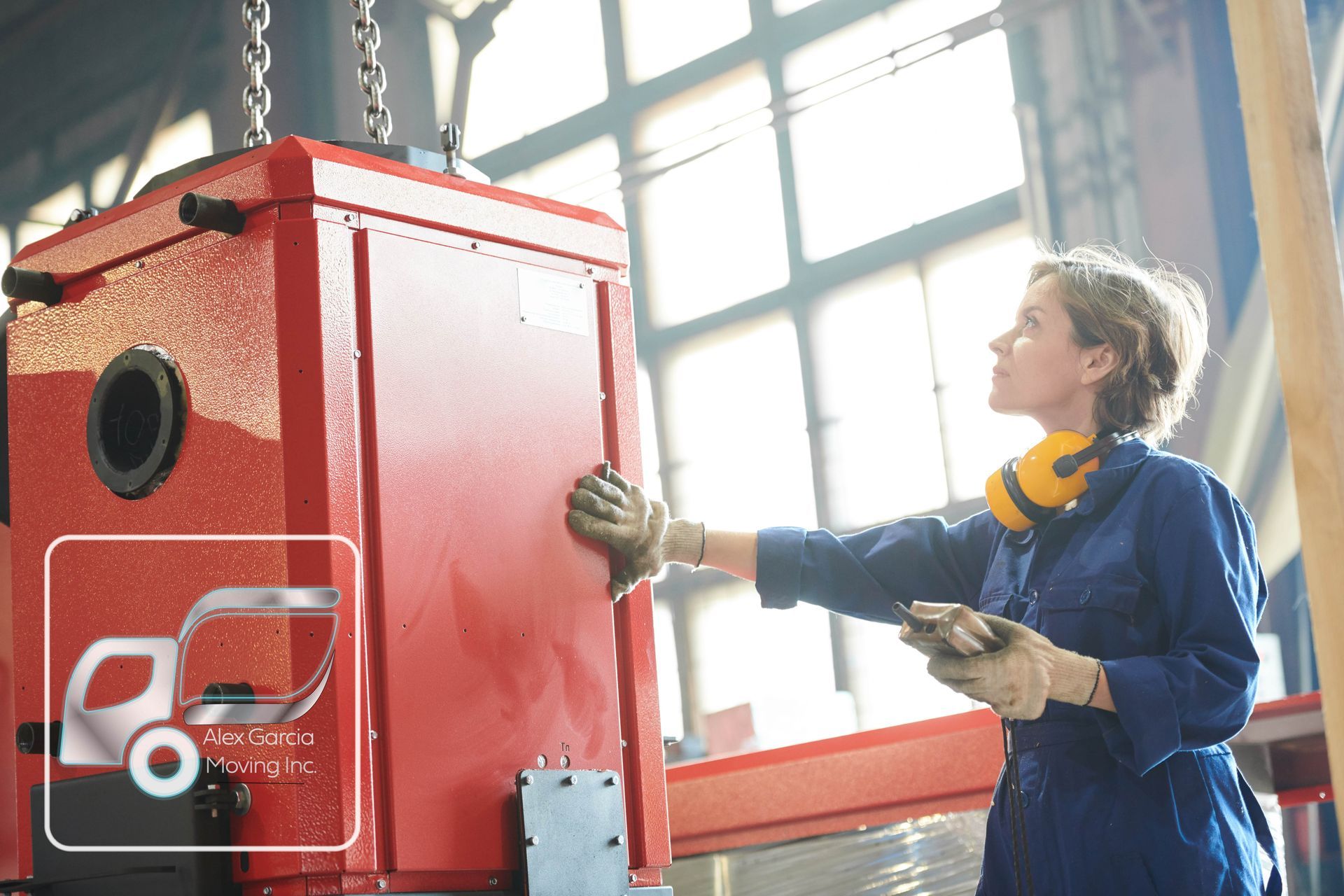 A woman is working on a red box in a factory.