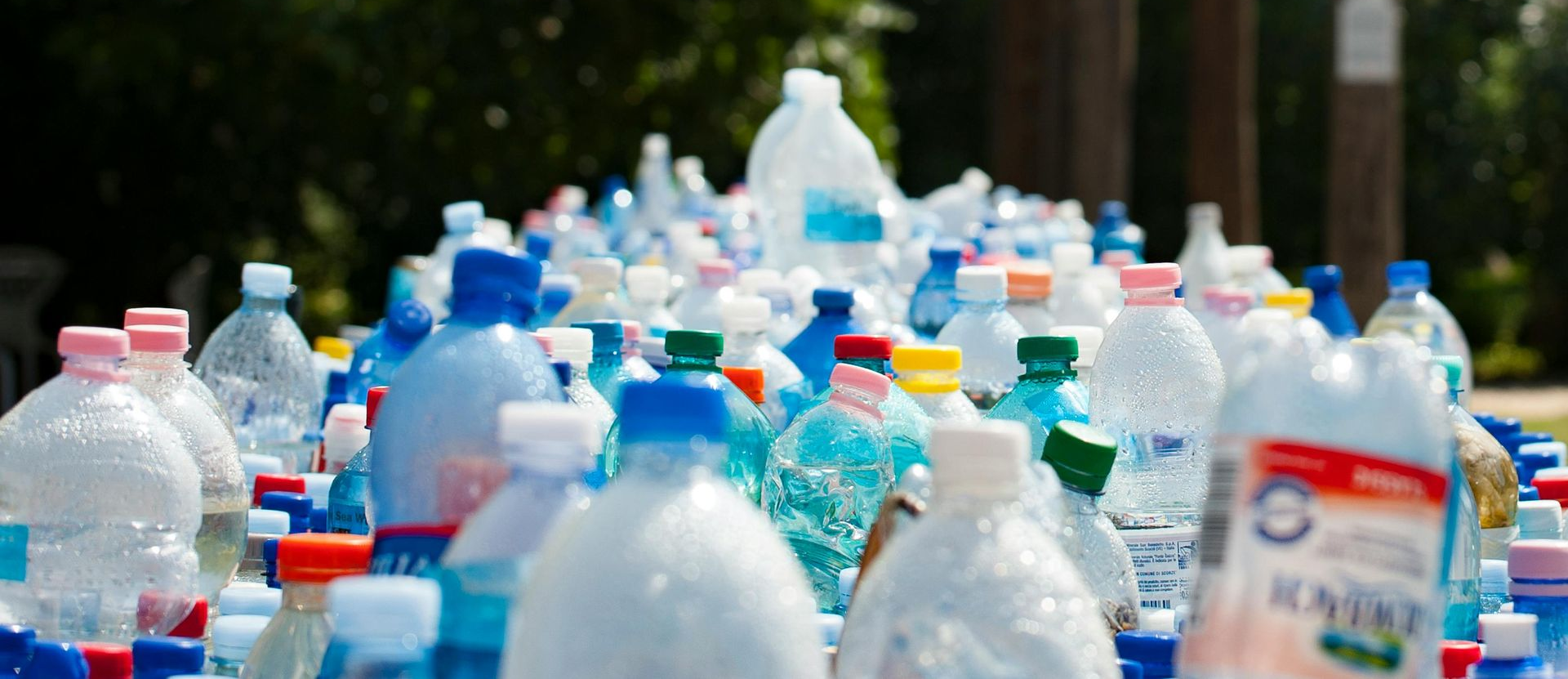 Assorted plastic water bottles piled outdoors in a recycling collection
