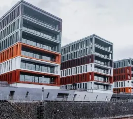 Modern multi-story buildings with orange accents in a snowy urban setting