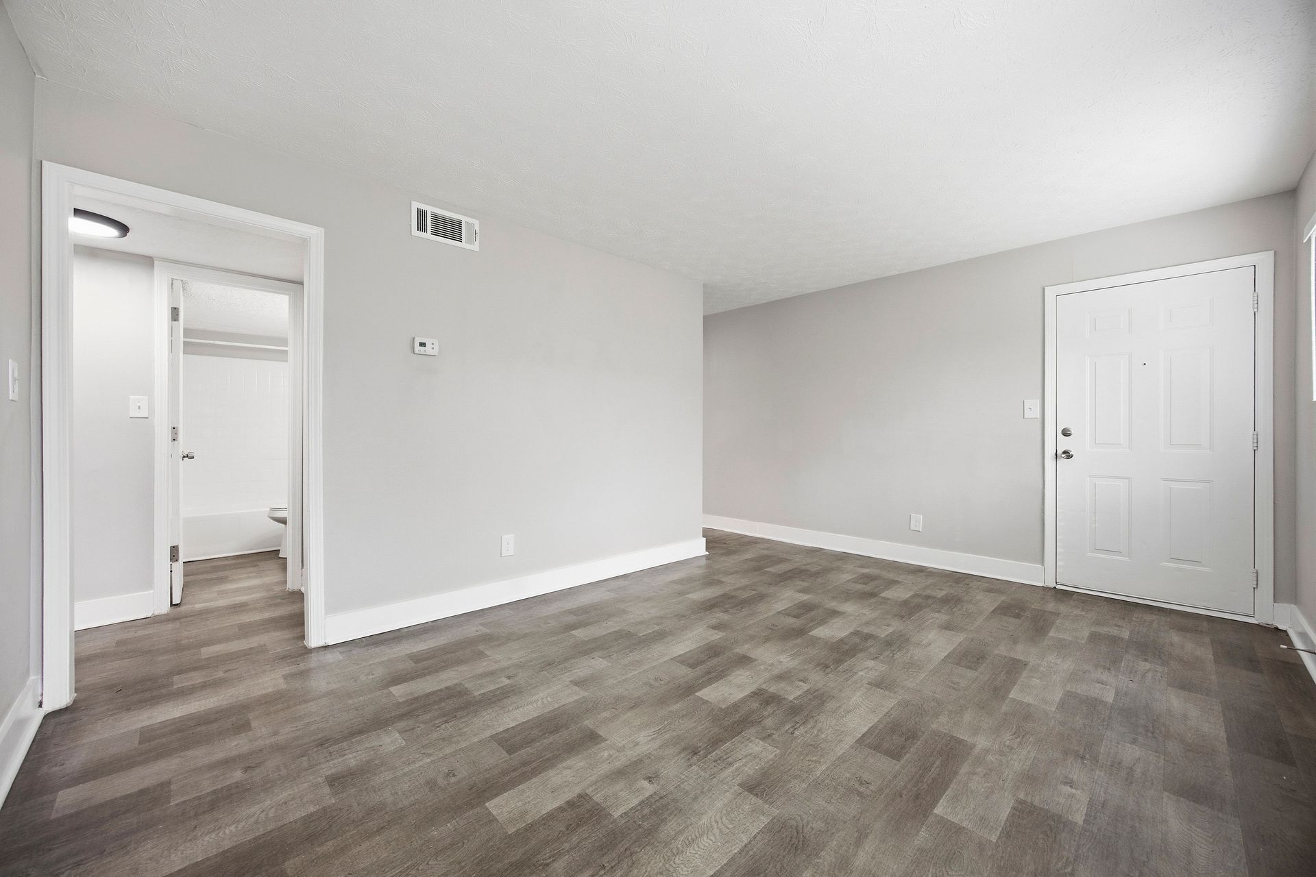 Empty gray bedroom with carpet, white walls, and two doors