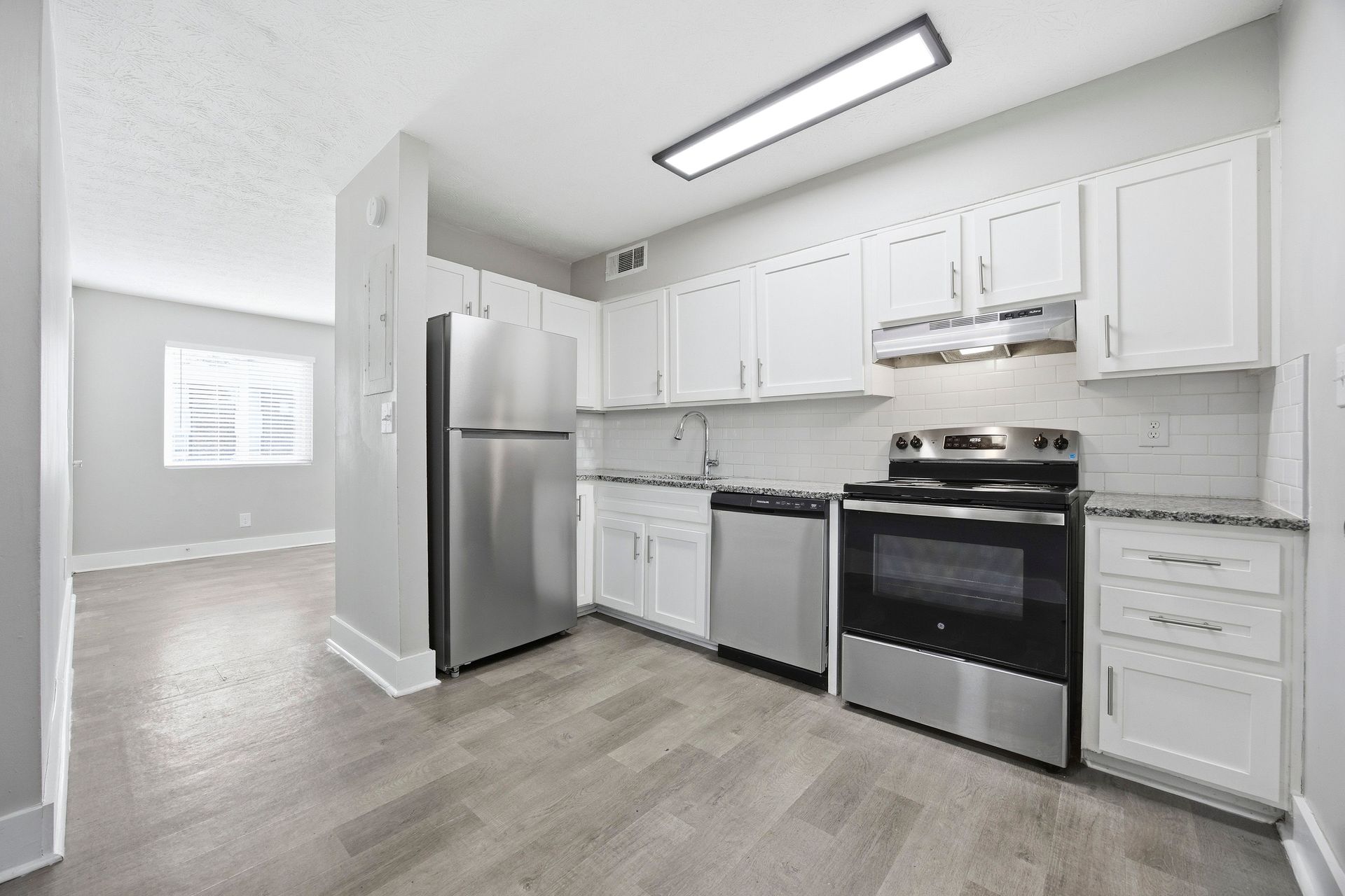 Bright white kitchen with stainless steel appliances and light wood floors