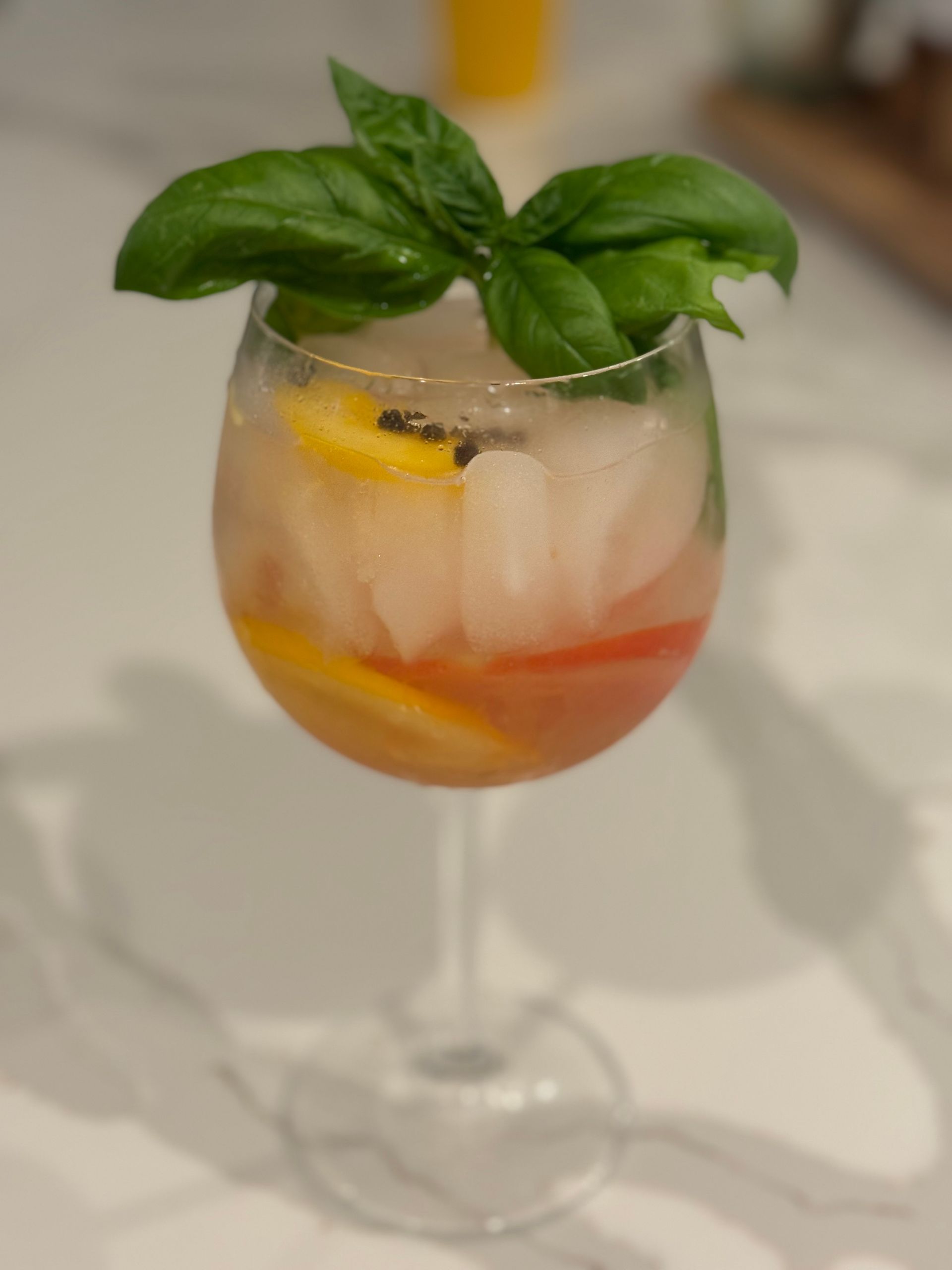 A close up of a wine glass filled with a drink and ice.