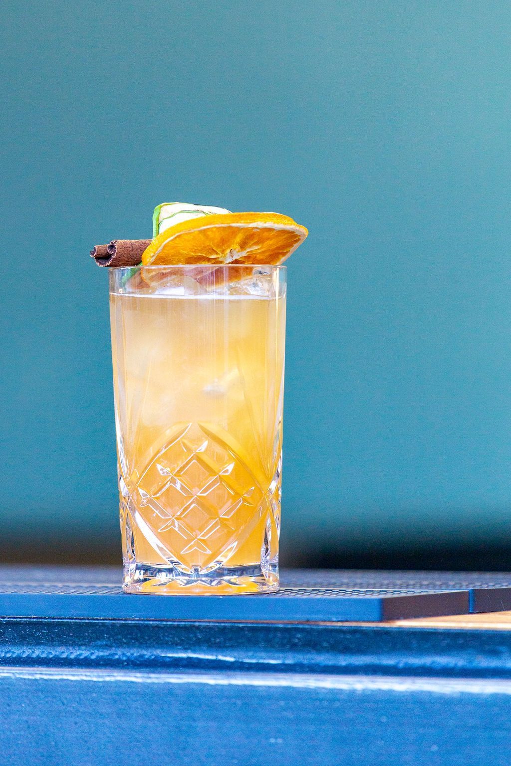 A close up of a drink in a tall glass on a table.