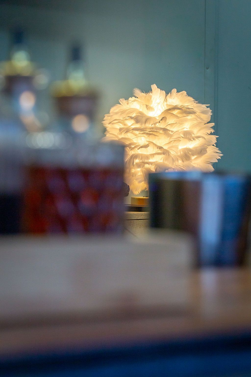 A table with a lamp and bottles on it.