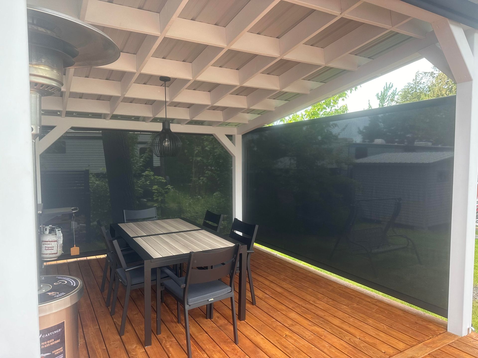 Espace repas extérieur avec terrasse en bois, table, chaises et paravent.