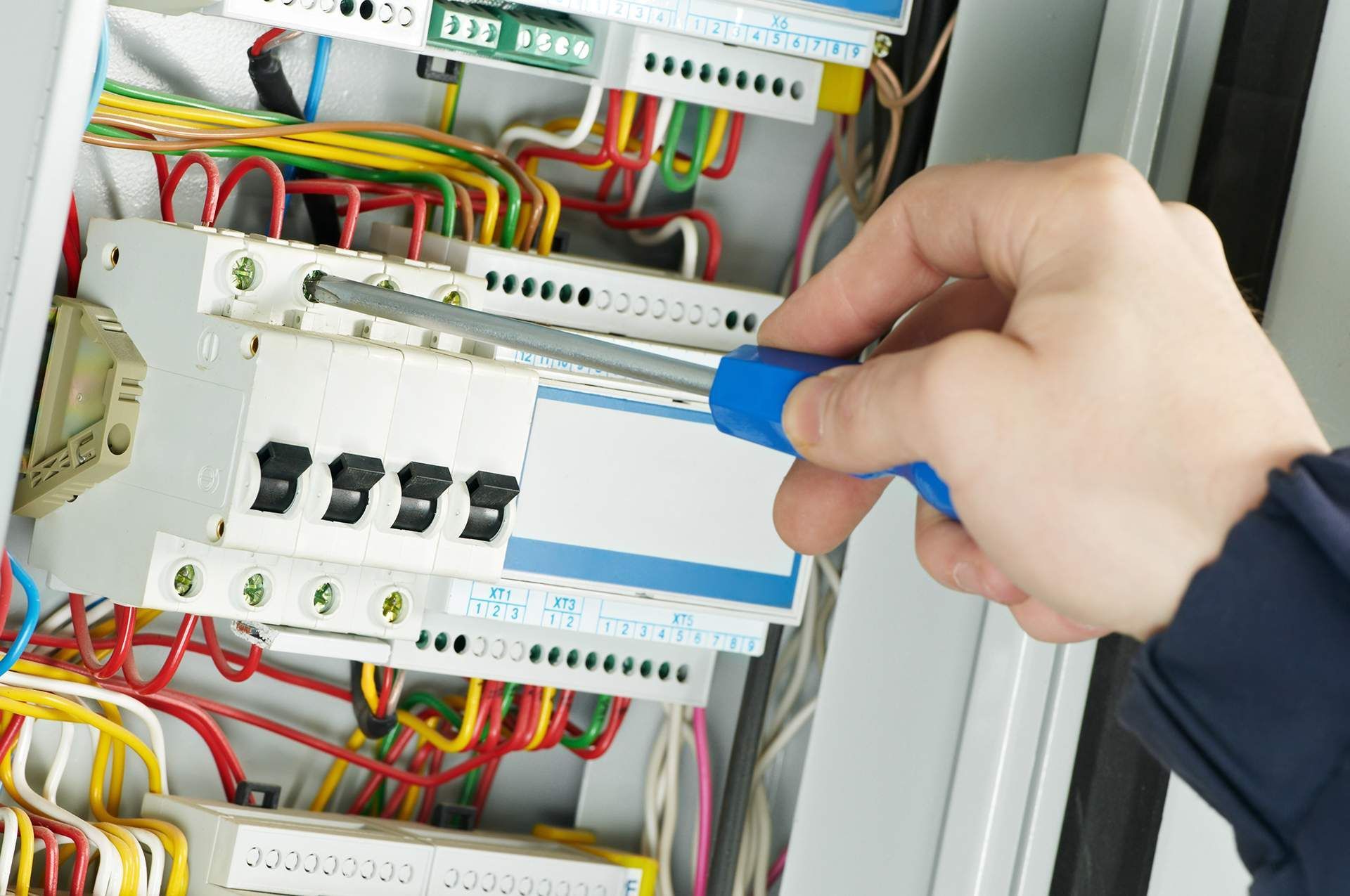 a person is working on an electrical box with a screwdriver