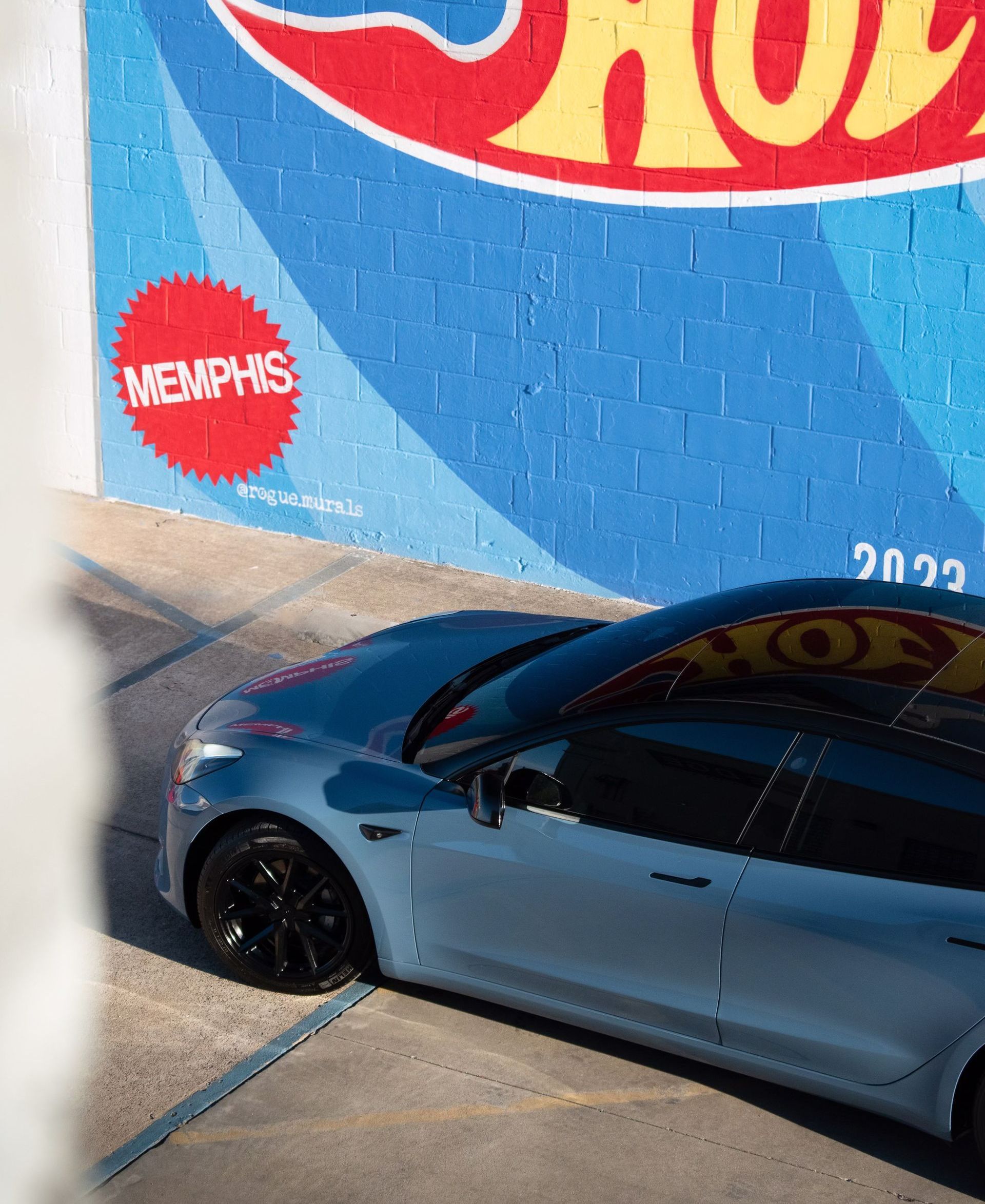 a car is parked in front of a hot wheels sign