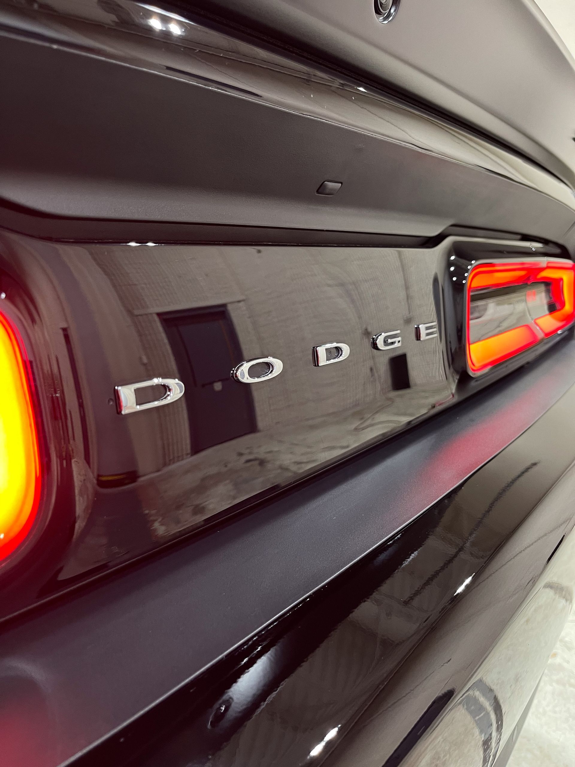 a black dodge challenger is parked in a garage.