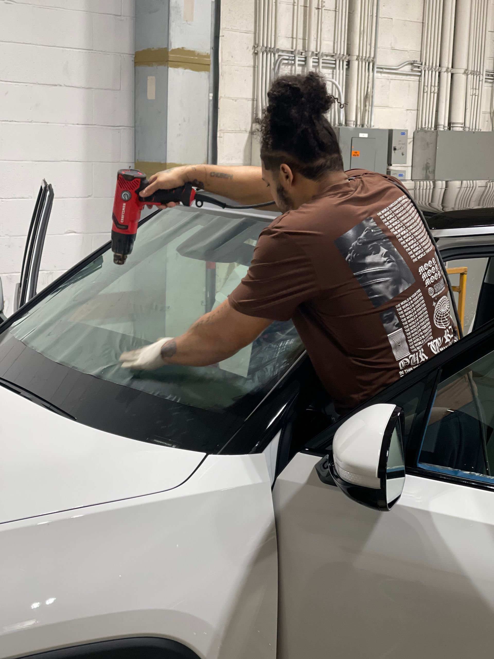 A man installing ceramic window tint at Eye Kandy Customs in Olive Branch, MS.